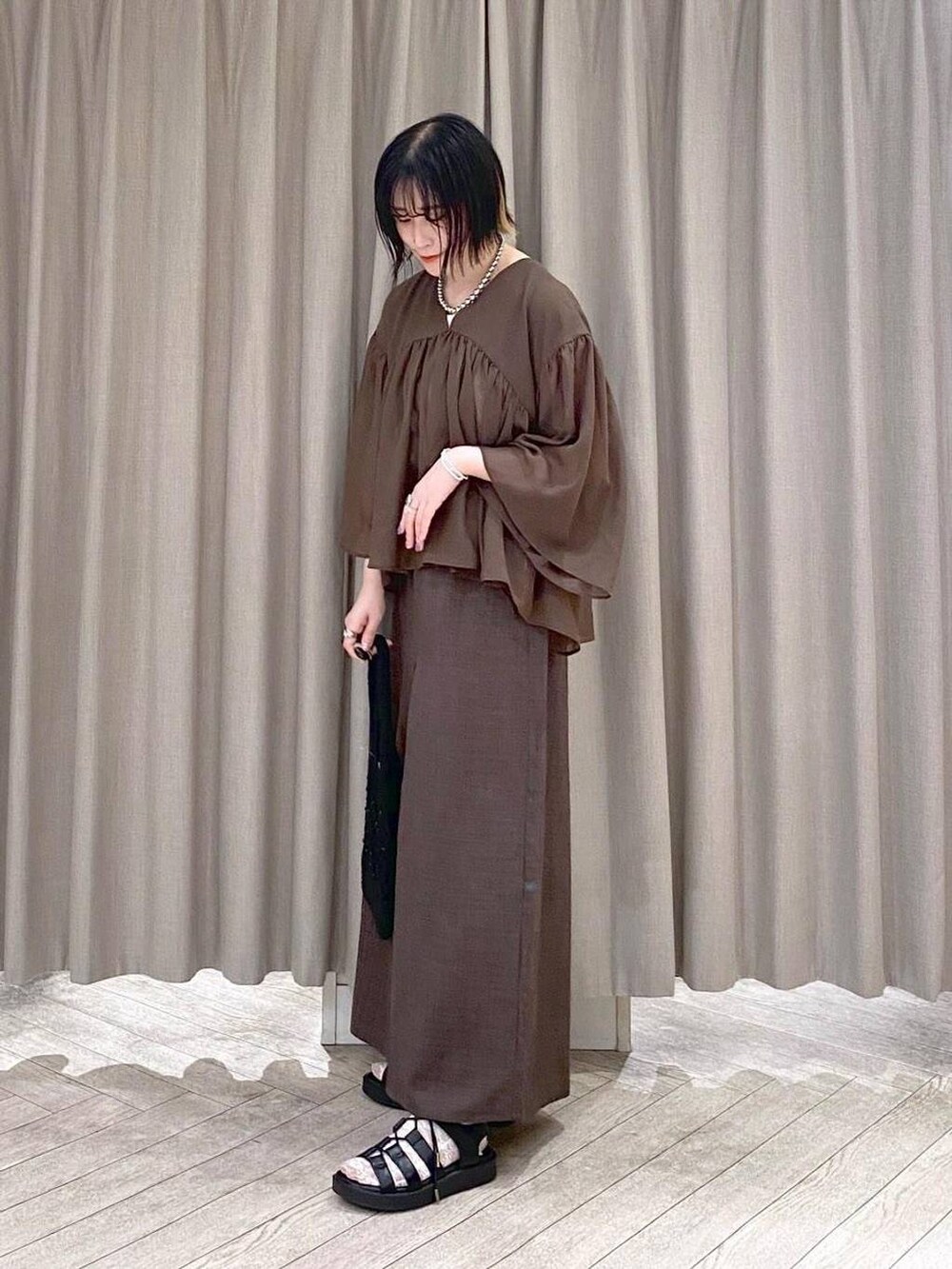ブラウン系のその他パンツ、ブラウン系のシャツ/ブラウス、ブラック系のトートバッグを着用したレディースの夏コーディネートの3枚目の写真
