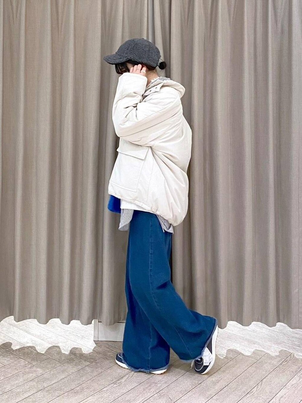ホワイト系のTシャツ/カットソー、ベージュ系のブルゾン、ブルー系のデニムパンツを着用したレディースの秋コーディネートの2枚目の写真