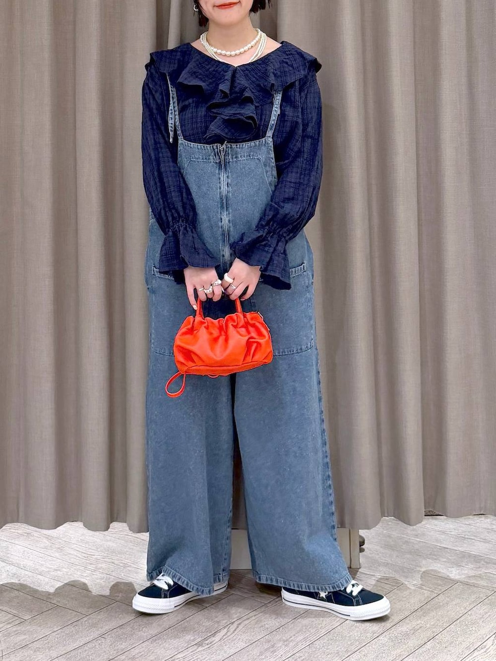 ブルー系のスニーカー、ブルー系のサロペット/オーバーオール、オレンジ系のショルダーバッグを着用したレディースの冬コーディネートの7枚目の写真