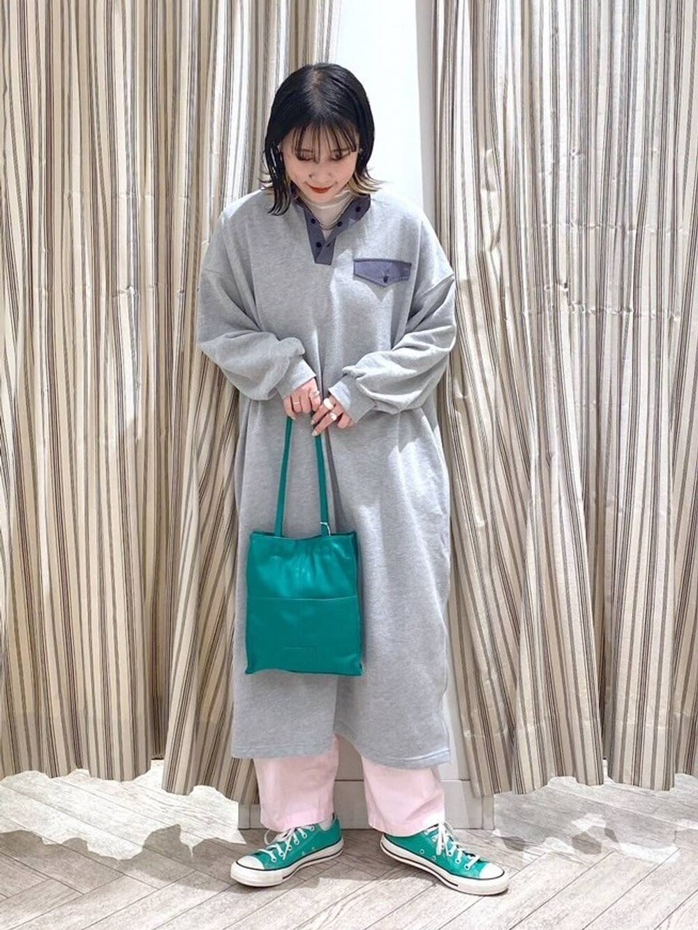 グレー系のワンピース、グリーン系のスニーカーを着用したレディースの春コーディネートの2枚目の写真