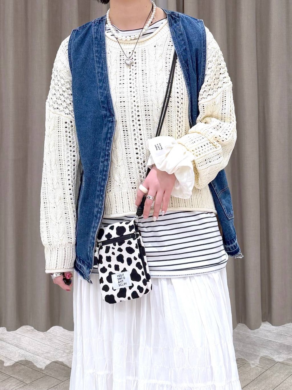 ブルー系のスニーカー、ブルー系のベスト、その他のショルダーバッグを着用したレディースの冬コーディネートの5枚目の写真