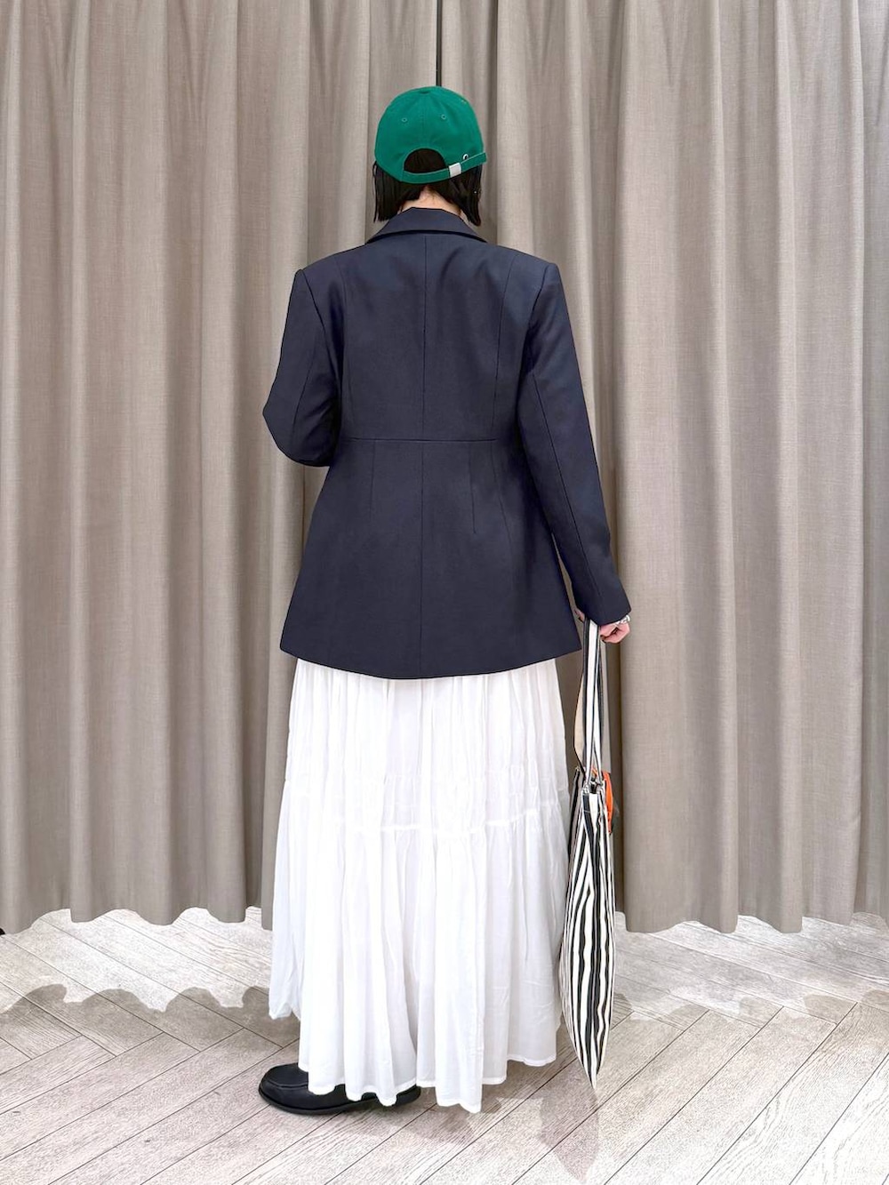 ホワイト系のスカート、ブラック系のローファー、ベージュ系のトートバッグを着用したレディースの冬コーディネートの5枚目の写真