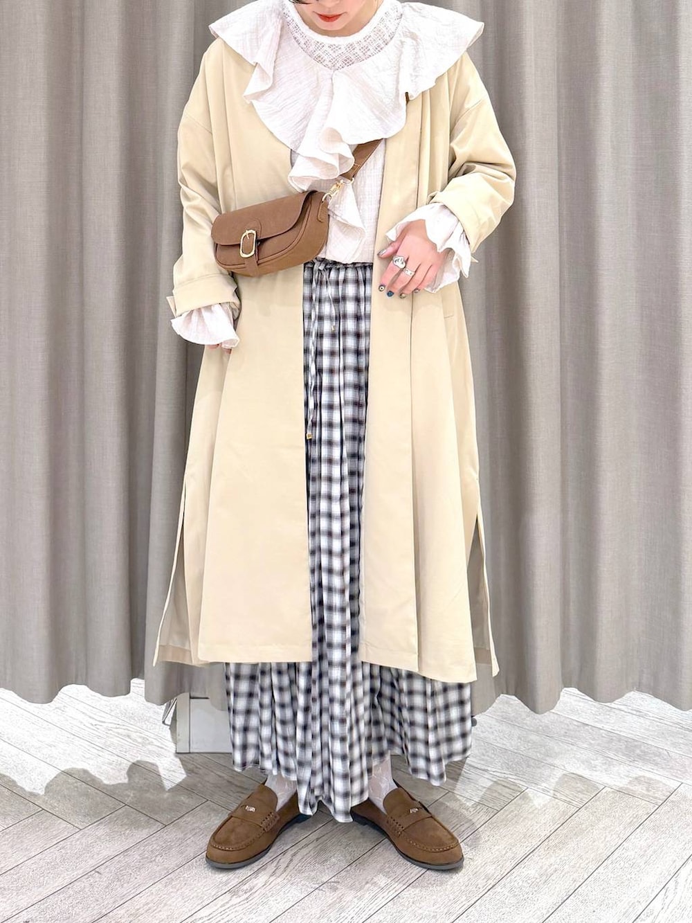 イエロー系のショルダーバッグ、ベージュ系のチェスターコート、イエロー系のローファーを着用したレディースの冬コーディネートの8枚目の写真