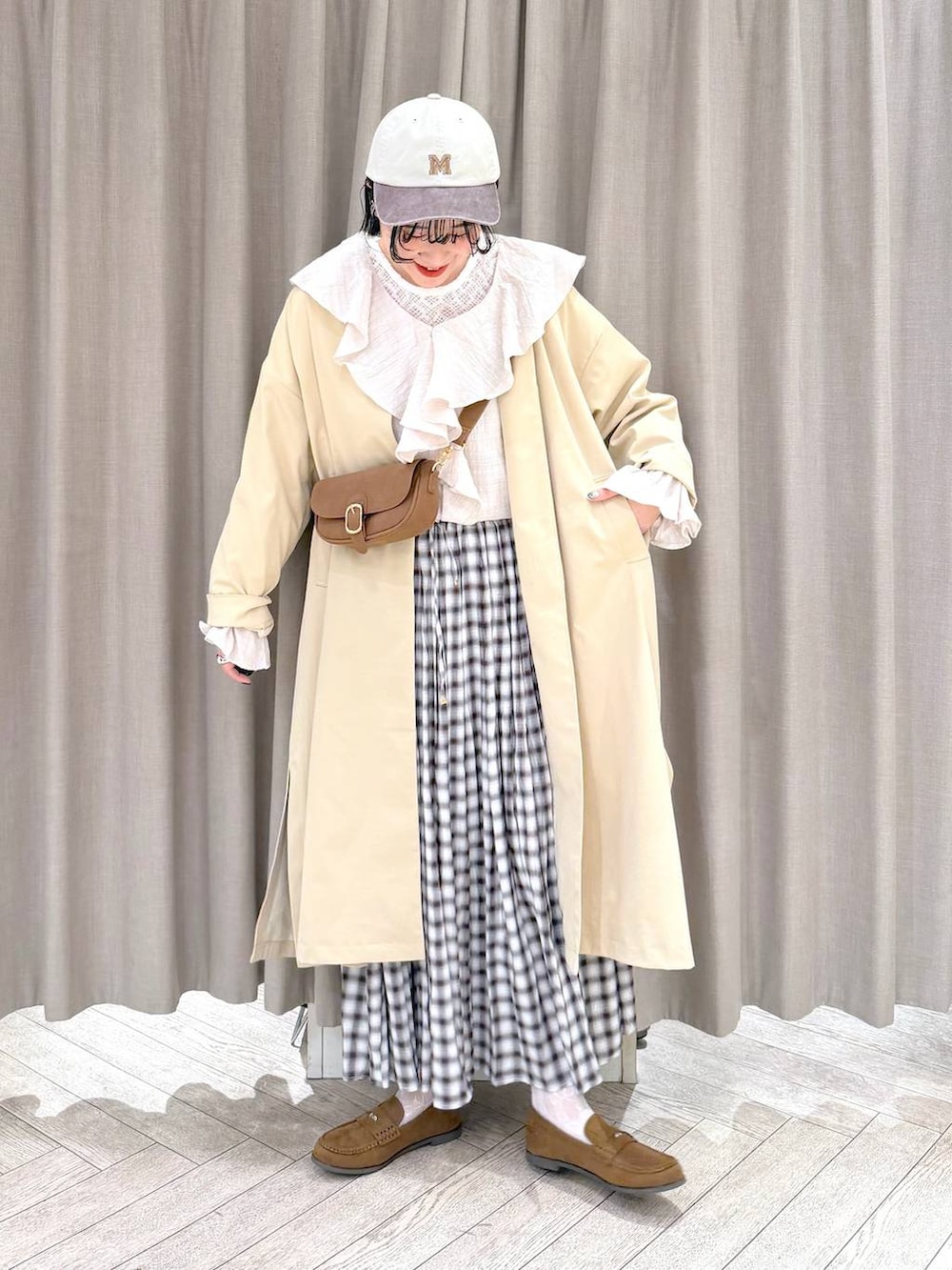 イエロー系のショルダーバッグ、ベージュ系のチェスターコート、イエロー系のローファーを着用したレディースの冬コーディネートの10枚目の写真