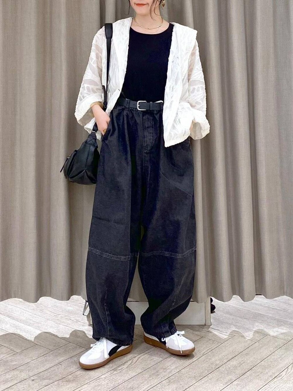 ブラック系のデニムパンツ、ホワイト系のスニーカー、ブラック系のショルダーバッグを着用したレディースの秋コーディネートの8枚目の写真