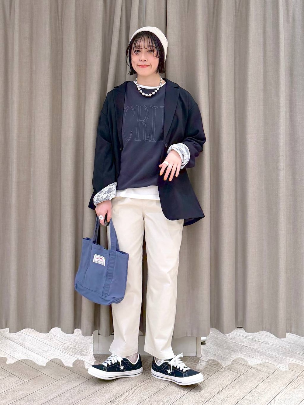 ブルー系のトートバッグ、ブルー系のスニーカー、ベージュ系のその他パンツを着用したレディースの春コーディネートの2枚目の写真