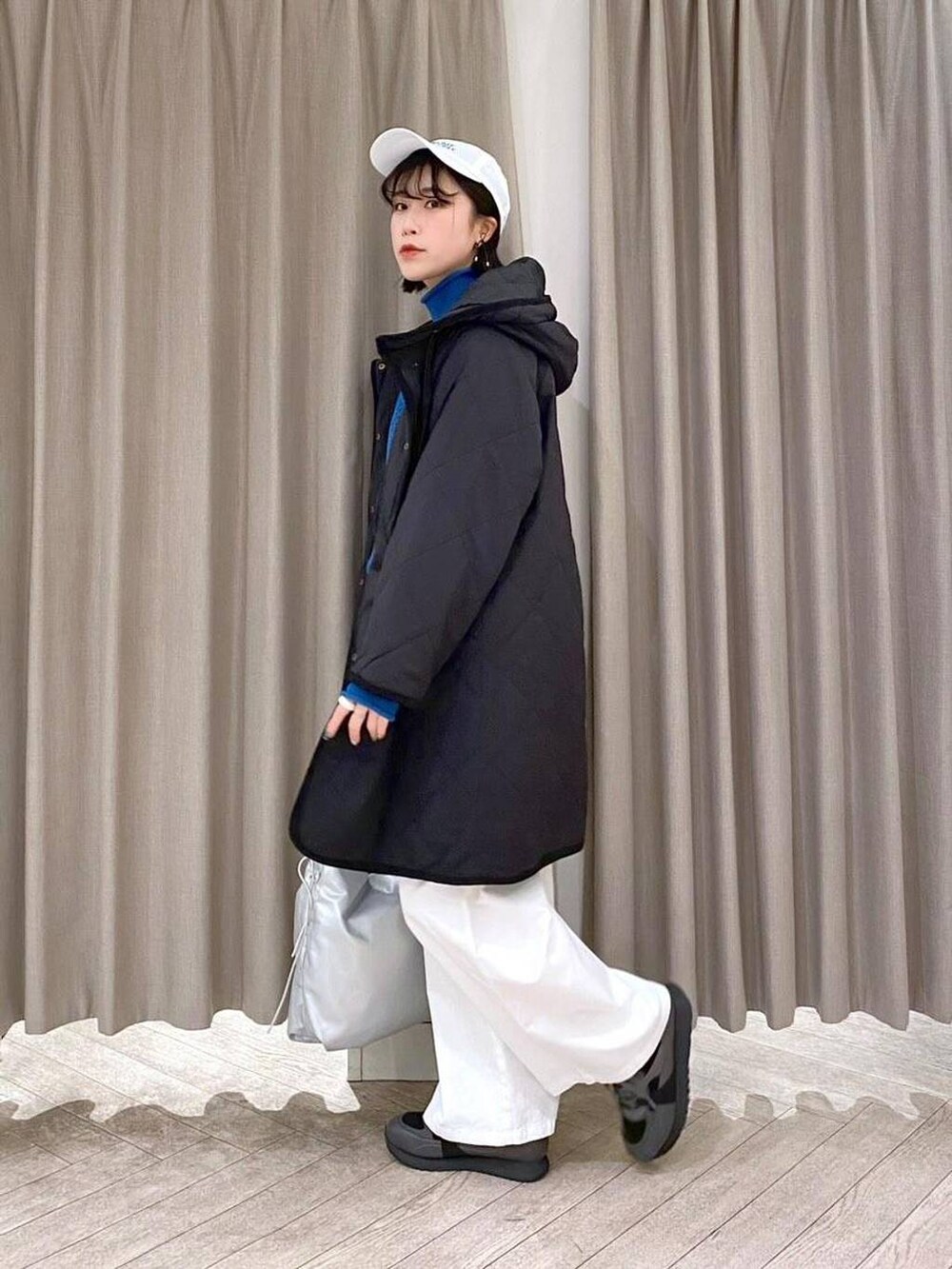 ブラック系のスニーカー、ブラック系のダウンジャケット/コート、その他のショルダーバッグを着用したレディースの冬コーディネートの3枚目の写真