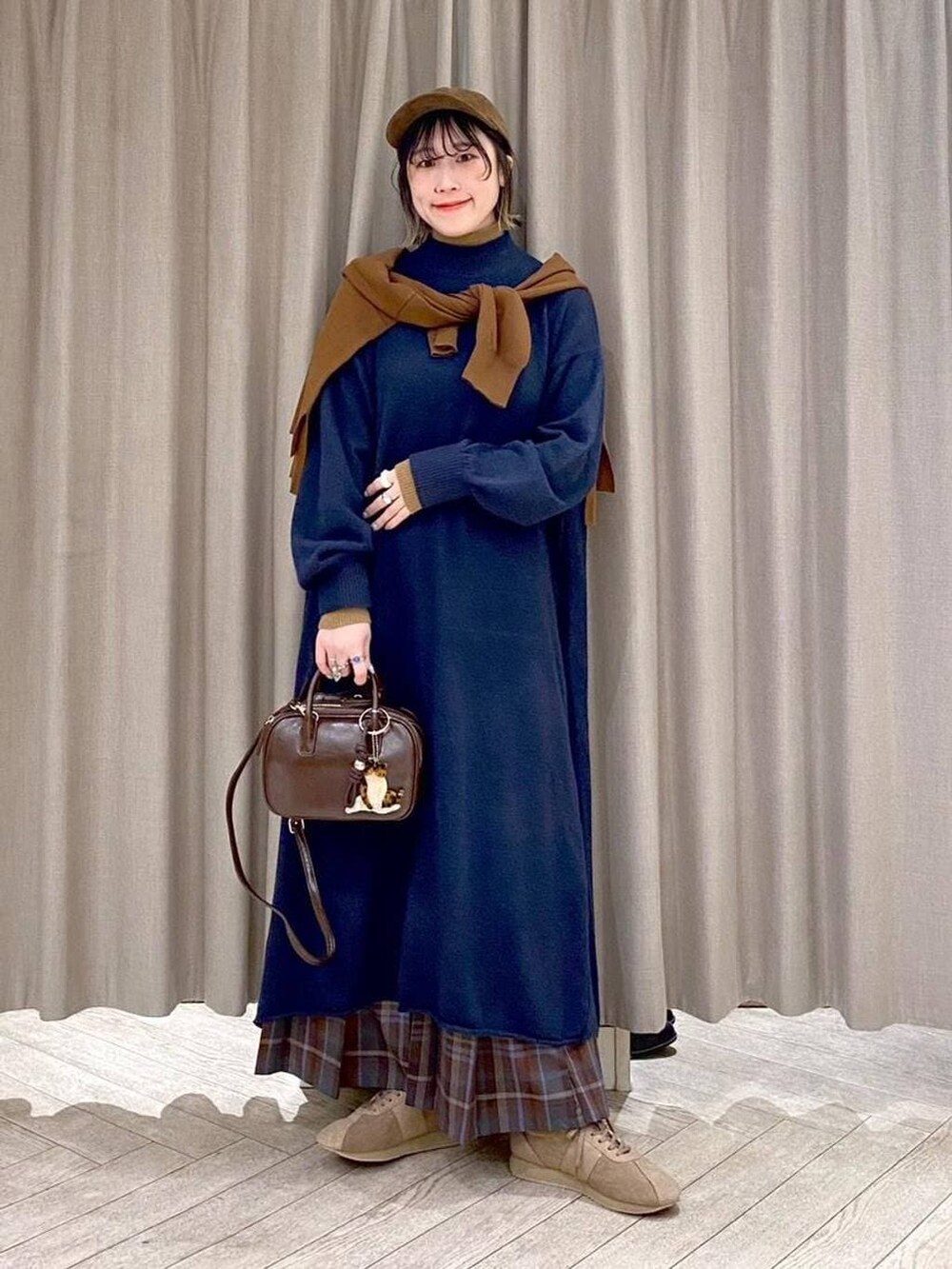 ブラウン系のスカート、イエロー系のカーディガン/ボレロ、ブラウン系のトートバッグを着用したレディースの冬コーディネートの10枚目の写真