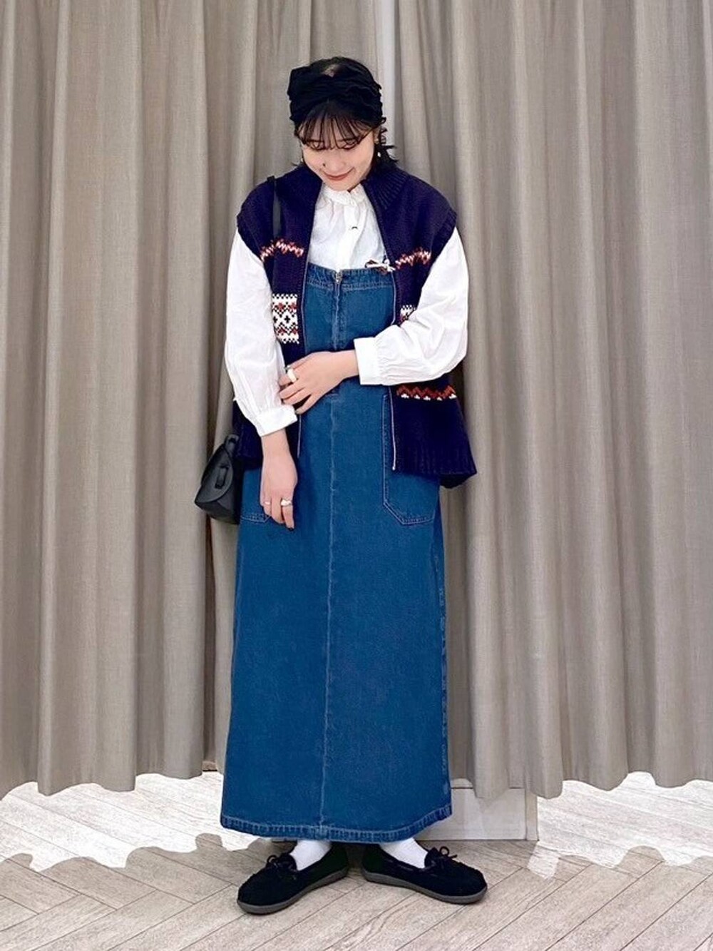 ブラック系のショルダーバッグ、ブルー系のワンピース、ブラック系のヘアバンドを着用したレディースの秋コーディネートの3枚目の写真