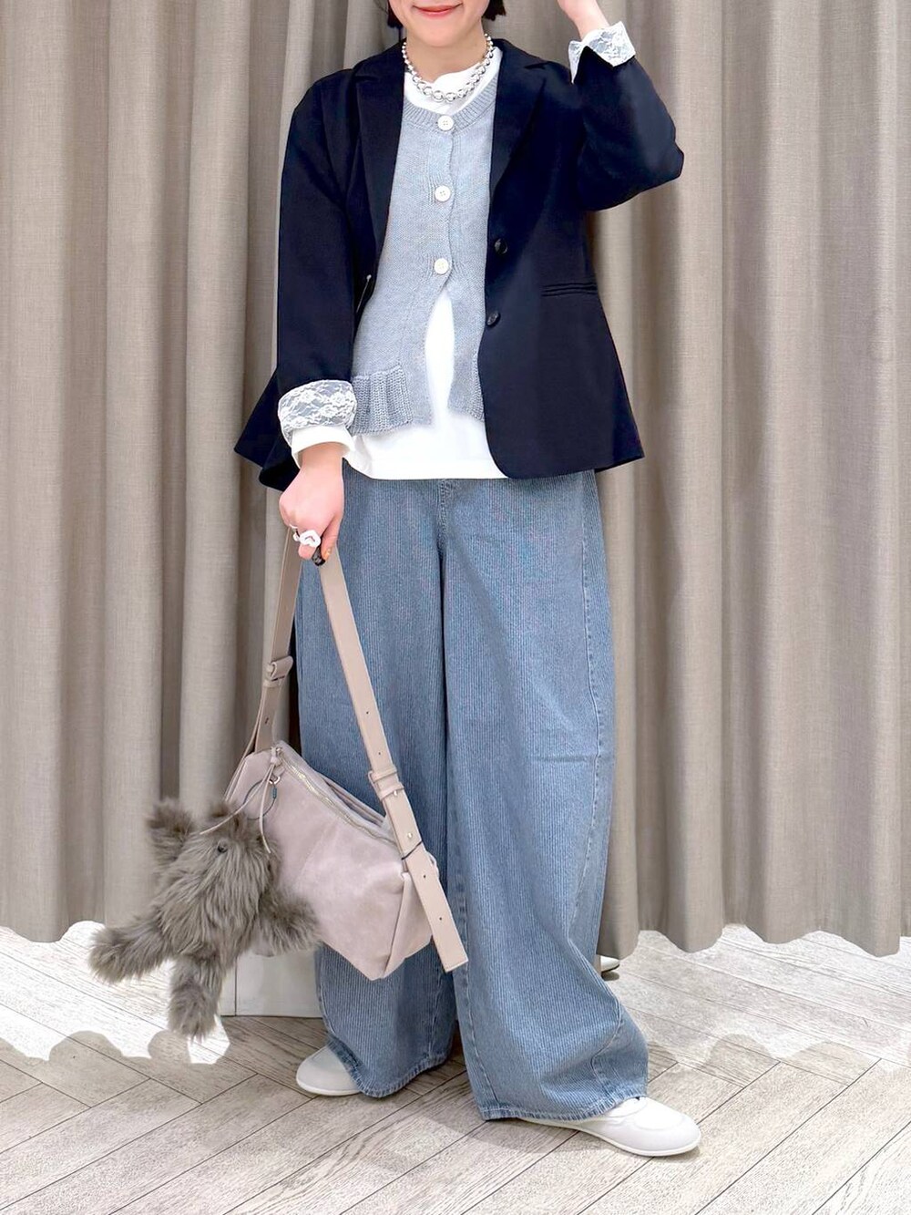 ブルー系のデニムパンツ、ブルー系のテーラードジャケット、グレー系のショルダーバッグを着用したレディースの春コーディネートの8枚目の写真