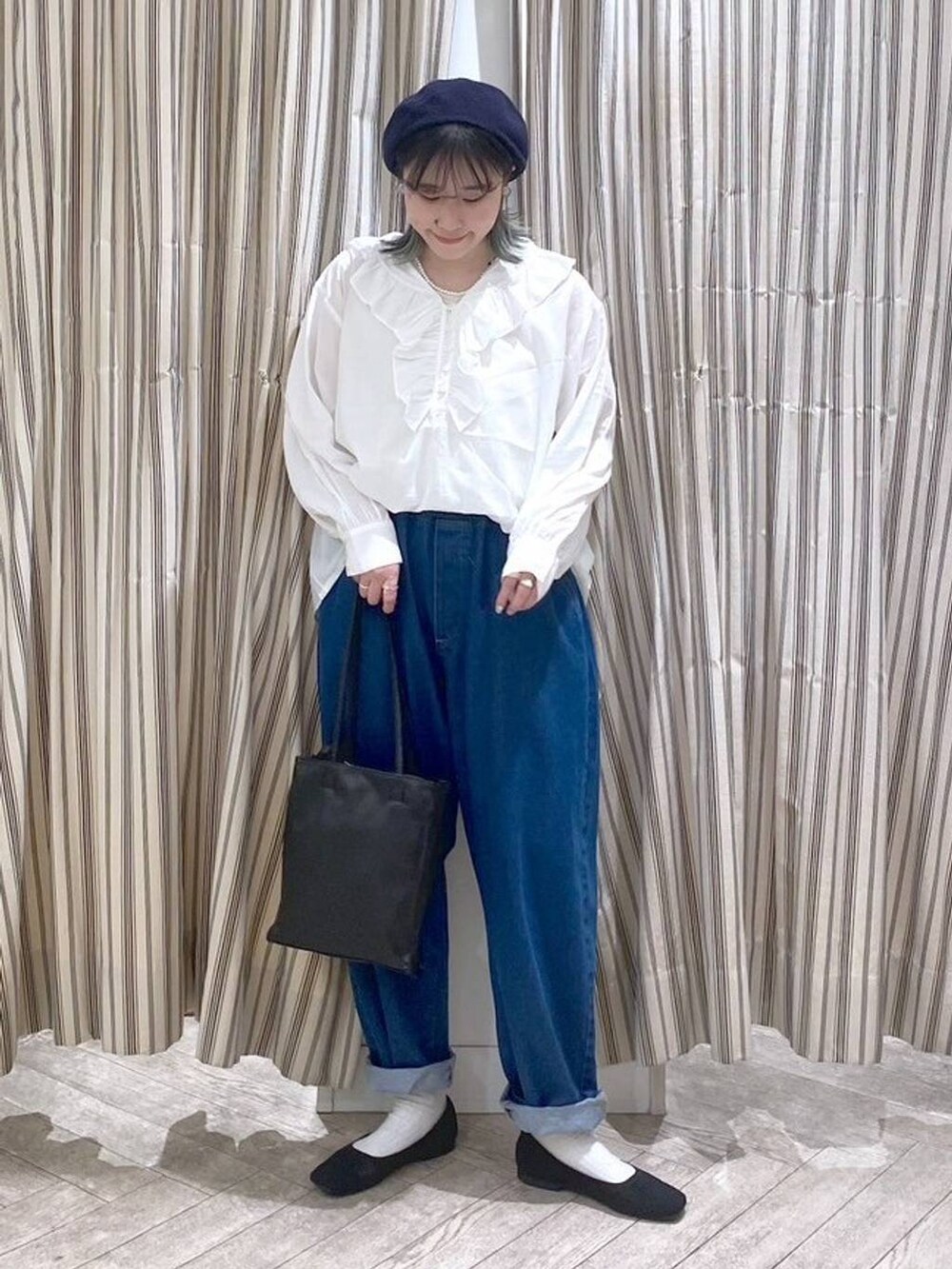 ホワイト系のシャツ/ブラウス、ベージュ系のタンクトップ、ブルー系のデニムパンツを着用したレディースの春コーディネートの4枚目の写真