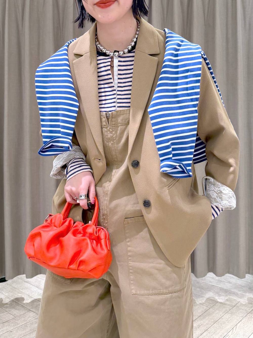 ブラック系のローファー、ベージュ系のサロペット/オーバーオール、オレンジ系のショルダーバッグを着用したレディースの冬コーディネートの5枚目の写真