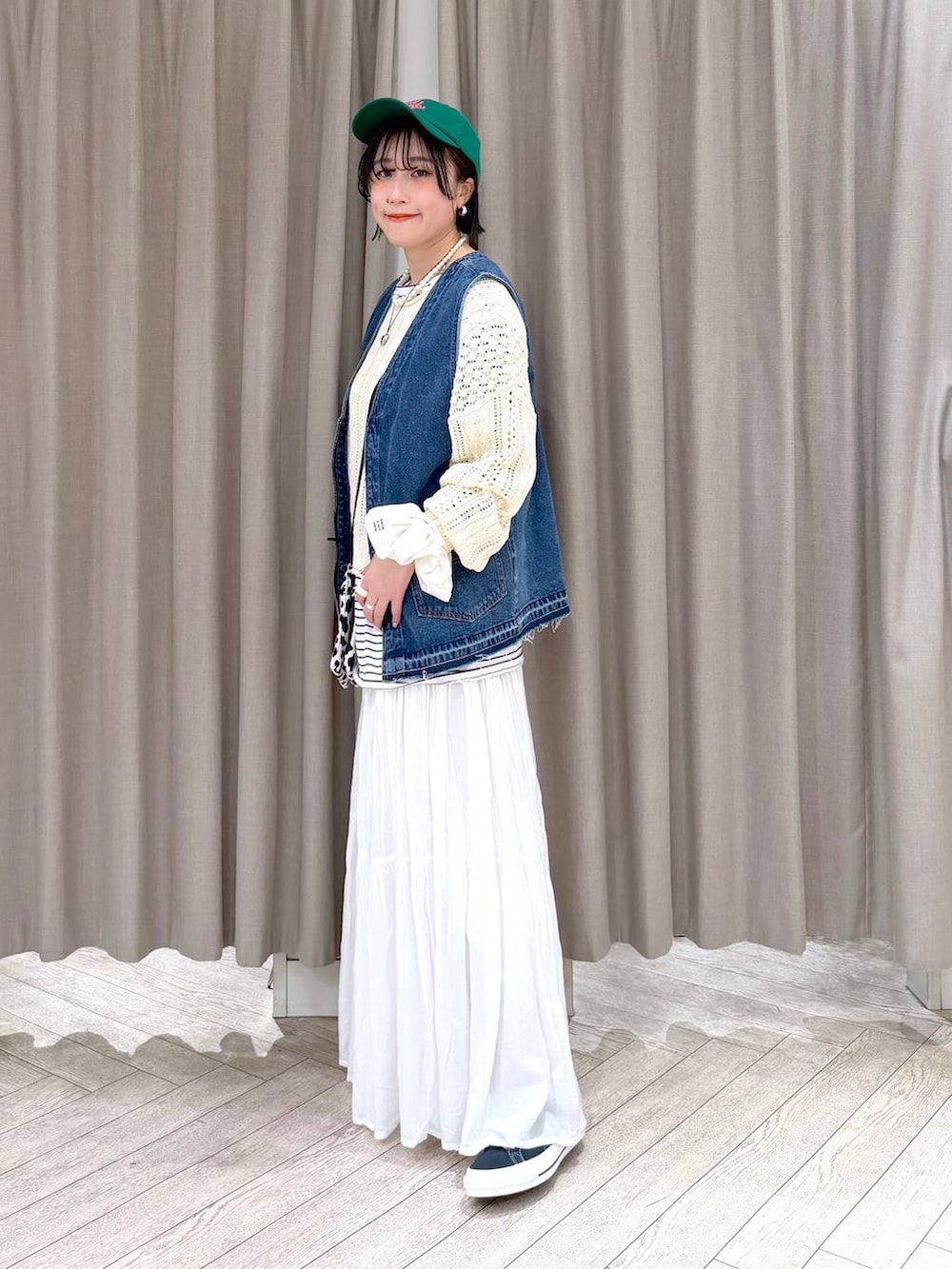 ブルー系のスニーカー、ブルー系のベスト、その他のショルダーバッグを着用したレディースの冬コーディネートの3枚目の写真