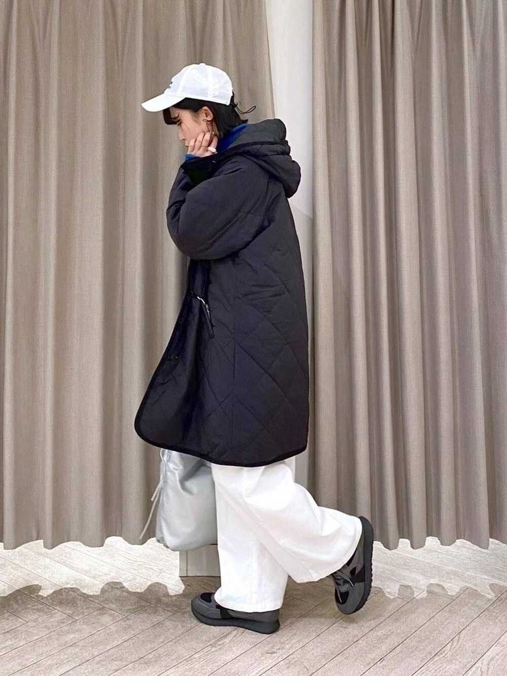 ブラック系のスニーカー、ブラック系のダウンジャケット/コート、その他のショルダーバッグを着用したレディースの冬コーディネートの4枚目の写真