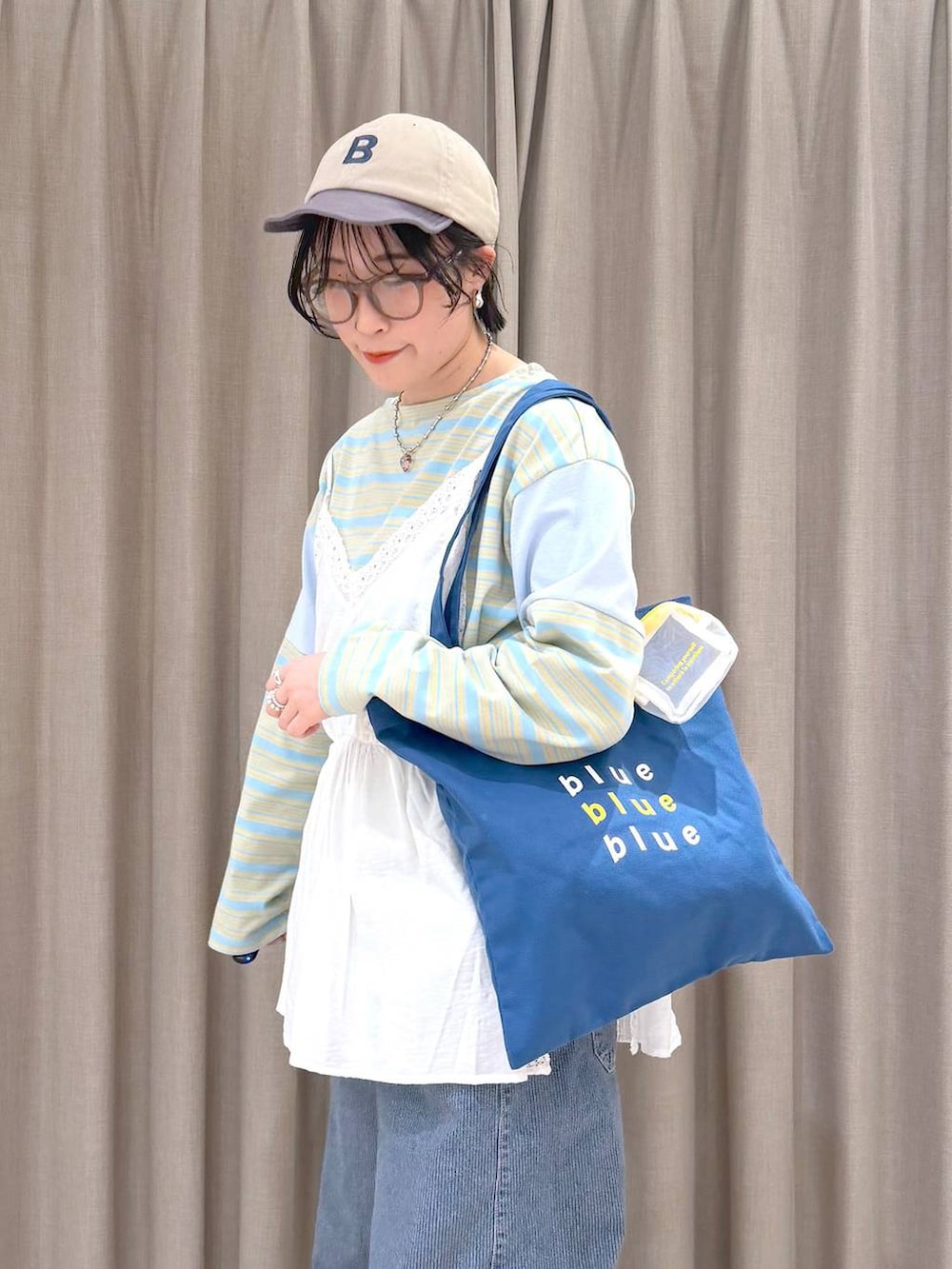 ブルー系のデニムパンツ、ブルー系のトートバッグ、ブルー系のTシャツ/カットソーを着用したレディースの春コーディネートの6枚目の写真