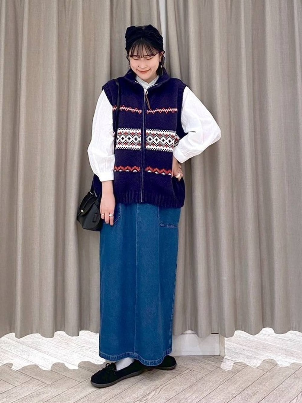 ブラック系のショルダーバッグ、ブルー系のワンピース、ブラック系のヘアバンドを着用したレディースの秋コーディネートの2枚目の写真