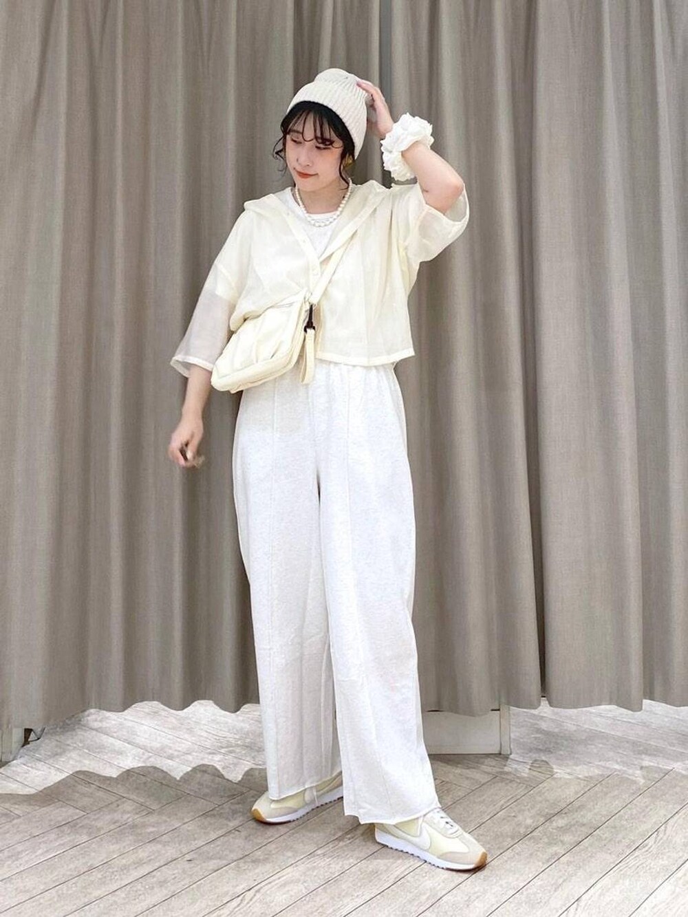 ベージュ系のショルダーバッグ、ベージュ系のシャツ/ブラウス、ベージュ系のスウェットパンツを着用したレディースの夏コーディネートの2枚目の写真