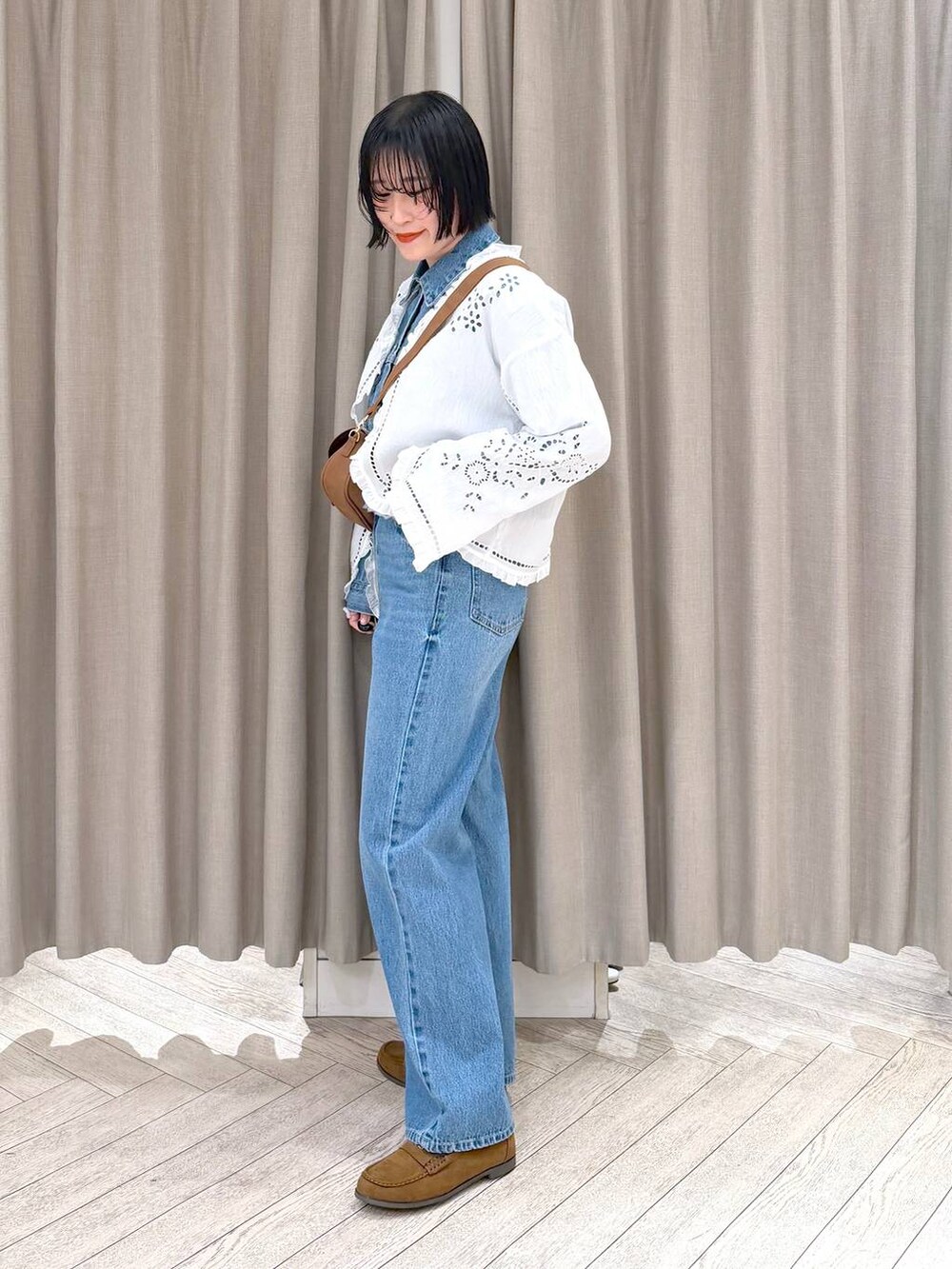イエロー系のショルダーバッグ、イエロー系のローファー、ブルー系のデニムパンツを着用したレディースの春コーディネートの4枚目の写真
