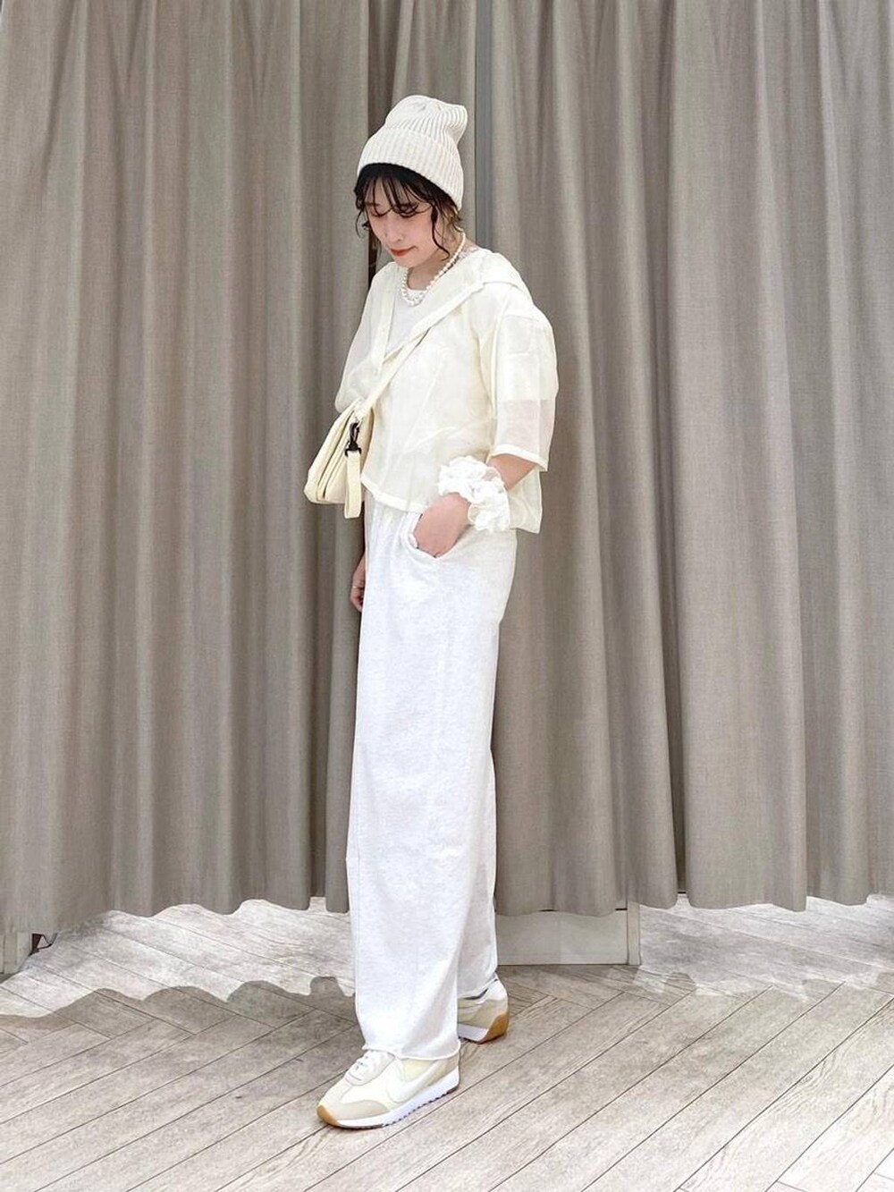 ベージュ系のショルダーバッグ、ベージュ系のシャツ/ブラウス、ベージュ系のスウェットパンツを着用したレディースの夏コーディネートの3枚目の写真