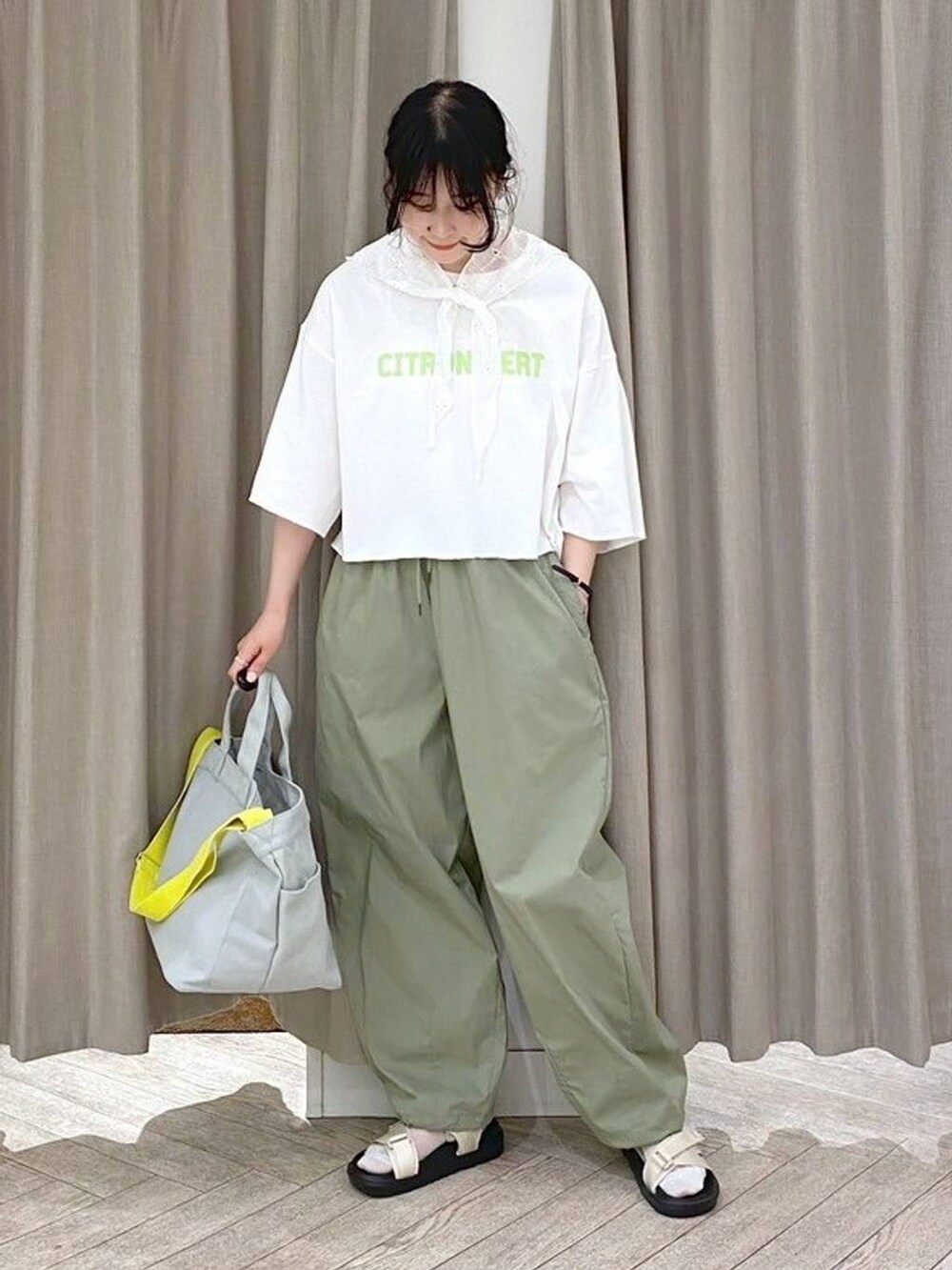 ベージュ系のサンダル、グリーン系のTシャツ/カットソー、グレー系のトートバッグを着用したレディースの夏コーディネートの8枚目の写真