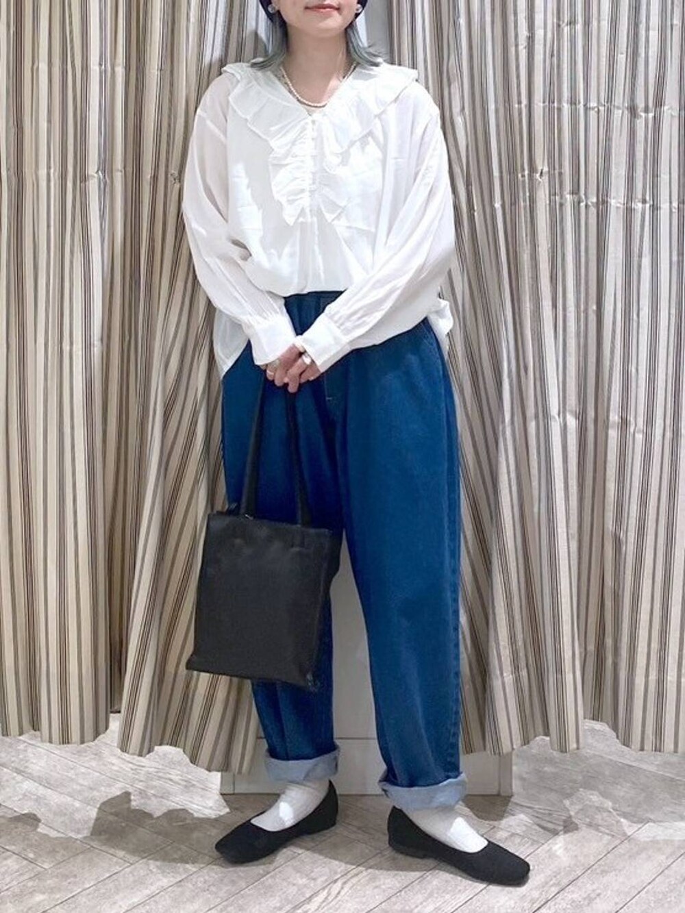 ホワイト系のシャツ/ブラウス、ベージュ系のタンクトップ、ブルー系のデニムパンツを着用したレディースの春コーディネートの5枚目の写真