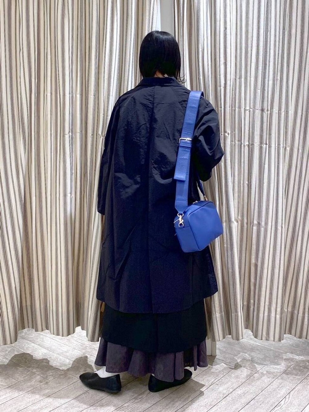 ブラック系のシャツ/ブラウス、ブラック系のジャンパースカート、ブラック系のスカートを着用したレディースの春コーディネートの4枚目の写真