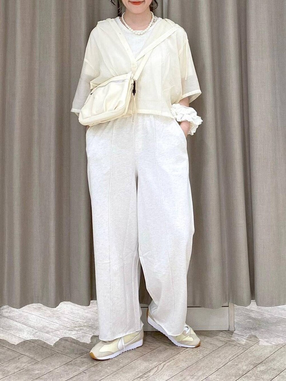 ベージュ系のショルダーバッグ、ベージュ系のシャツ/ブラウス、ベージュ系のスウェットパンツを着用したレディースの夏コーディネートの7枚目の写真