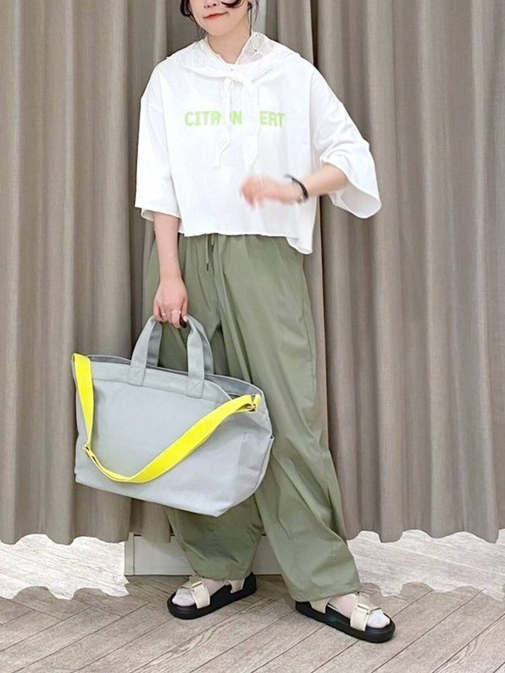 ベージュ系のサンダル、グリーン系のTシャツ/カットソー、グレー系のトートバッグを着用したレディースの夏コーディネートの7枚目の写真