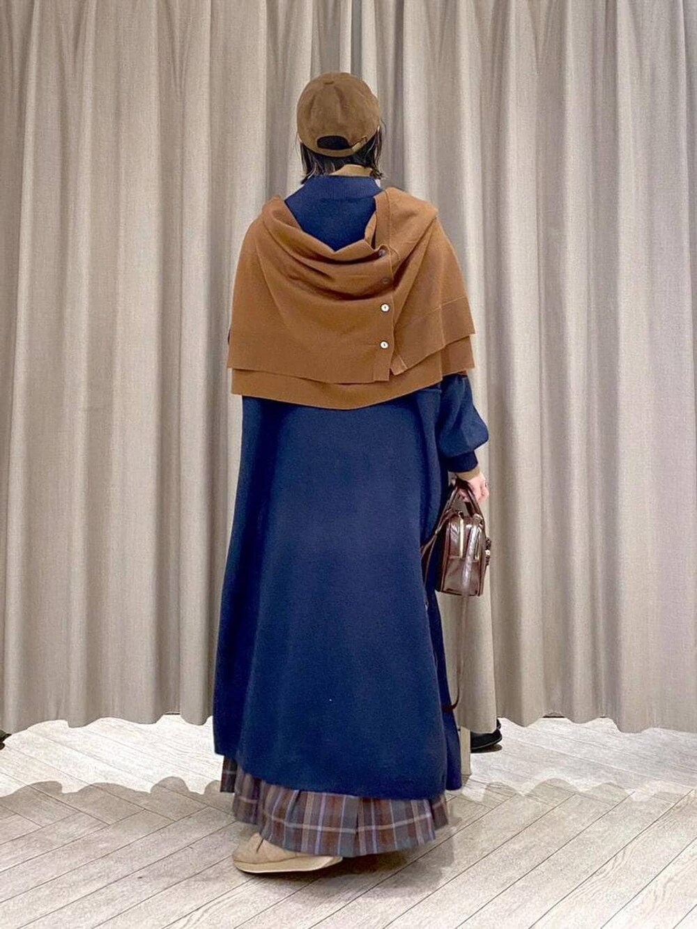 ブラウン系のスカート、イエロー系のカーディガン/ボレロ、ブラウン系のトートバッグを着用したレディースの冬コーディネートの5枚目の写真