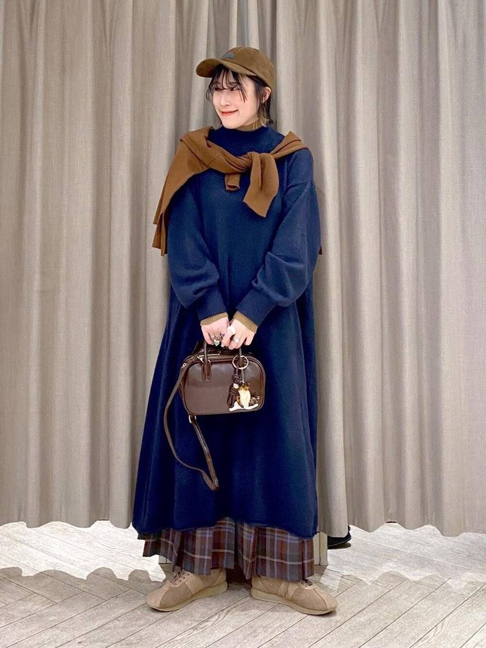 ブラウン系のスカート、イエロー系のカーディガン/ボレロ、ブラウン系のトートバッグを着用したレディースの冬コーディネートの2枚目の写真