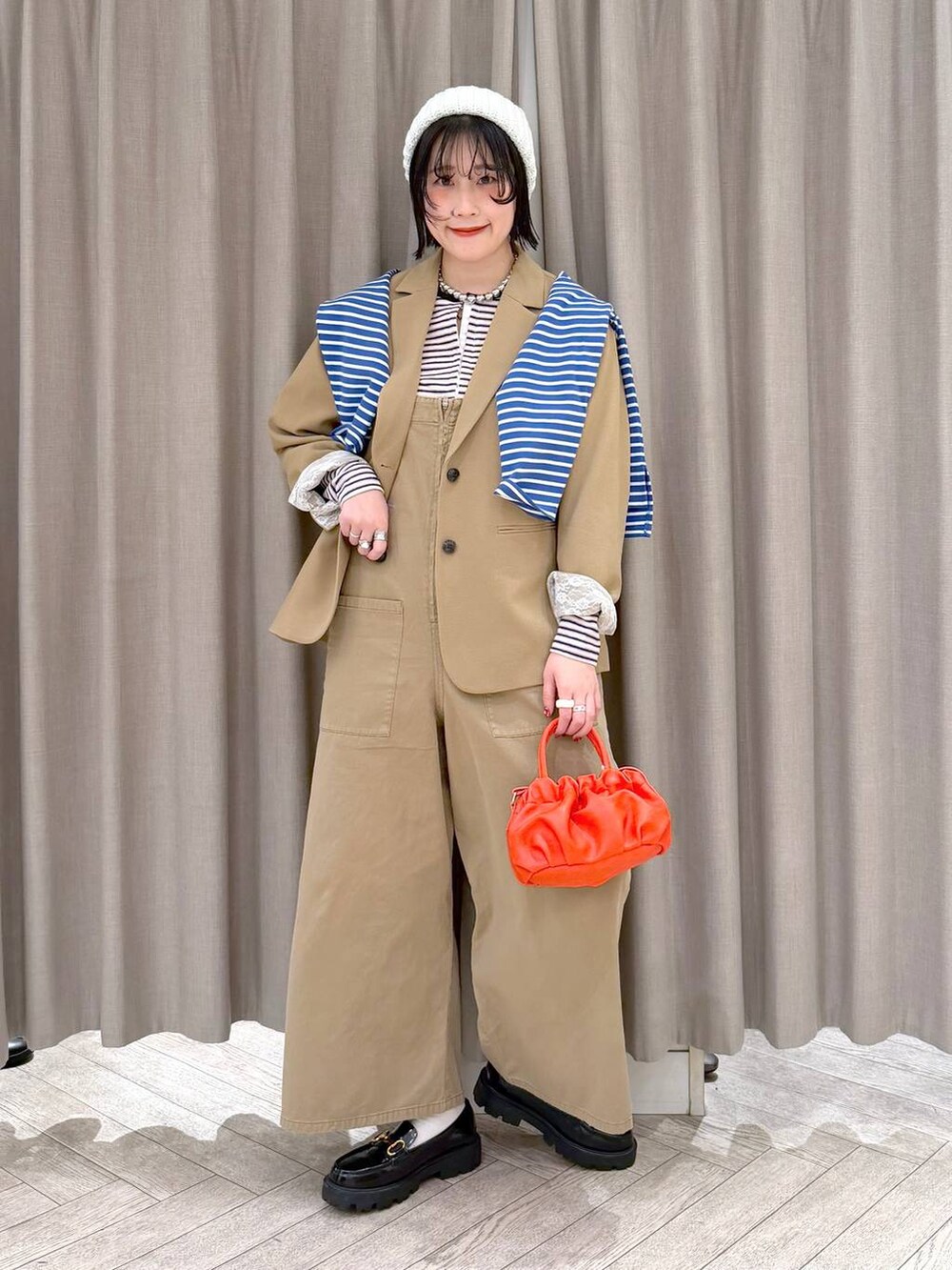 ブラック系のローファー、ベージュ系のサロペット/オーバーオール、オレンジ系のショルダーバッグを着用したレディースの冬コーディネートの10枚目の写真