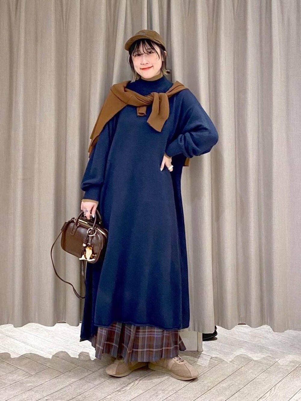 ブラウン系のスカート、イエロー系のカーディガン/ボレロ、ブラウン系のトートバッグを着用したレディースの冬コーディネートの3枚目の写真