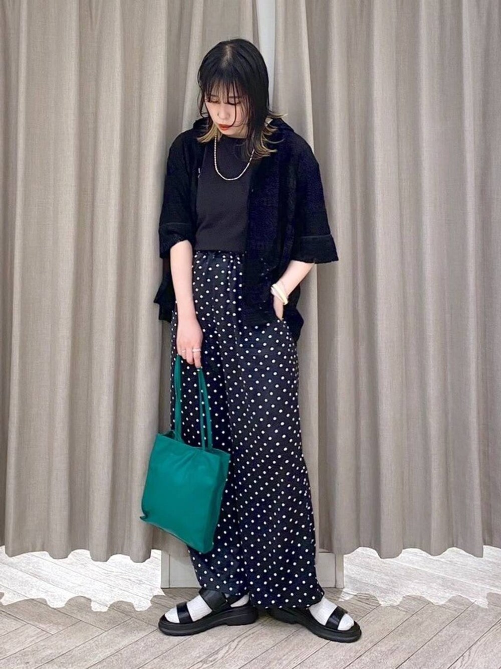 ブラック系のTシャツ/カットソー、ブラック系のサンダル、グリーン系のショルダーバッグを着用したレディースの春コーディネートの2枚目の写真