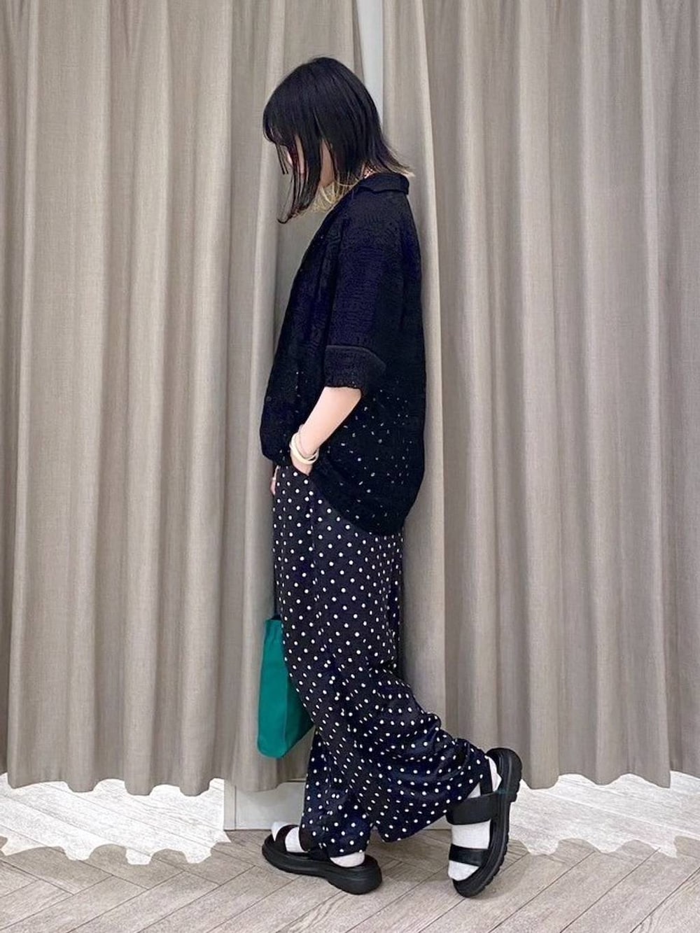 ブラック系のTシャツ/カットソー、ブラック系のサンダル、グリーン系のショルダーバッグを着用したレディースの春コーディネートの3枚目の写真