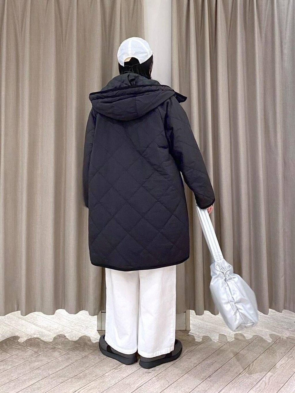 ブラック系のスニーカー、ブラック系のダウンジャケット/コート、その他のショルダーバッグを着用したレディースの冬コーディネートの5枚目の写真