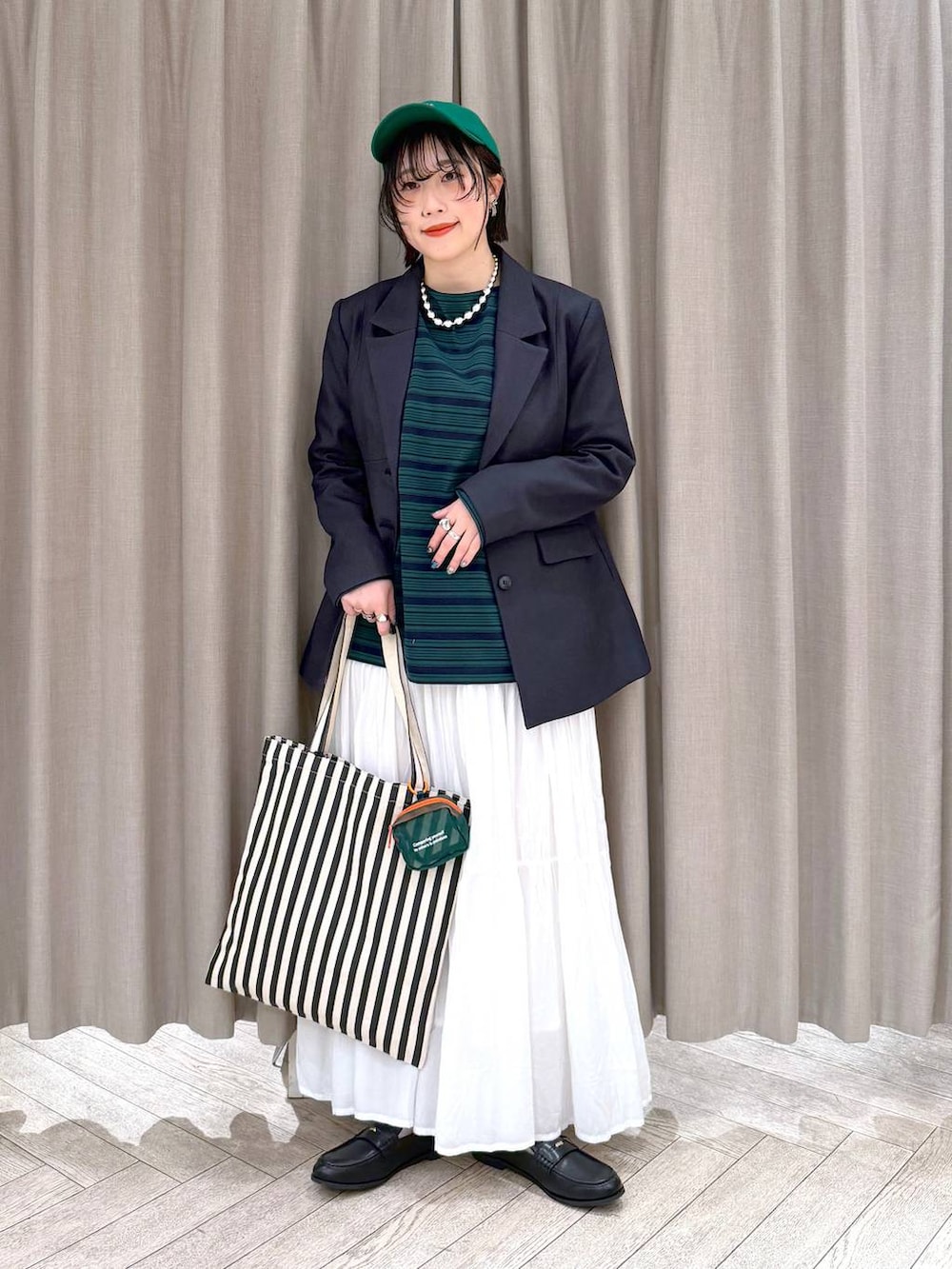 ホワイト系のスカート、ブラック系のローファー、ベージュ系のトートバッグを着用したレディースの冬コーディネートの3枚目の写真