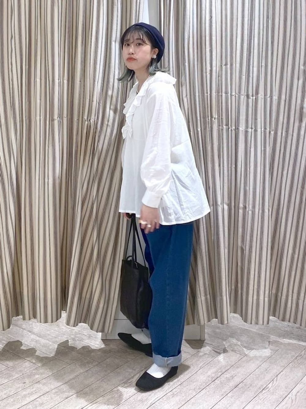 ホワイト系のシャツ/ブラウス、ベージュ系のタンクトップ、ブルー系のデニムパンツを着用したレディースの春コーディネートの2枚目の写真