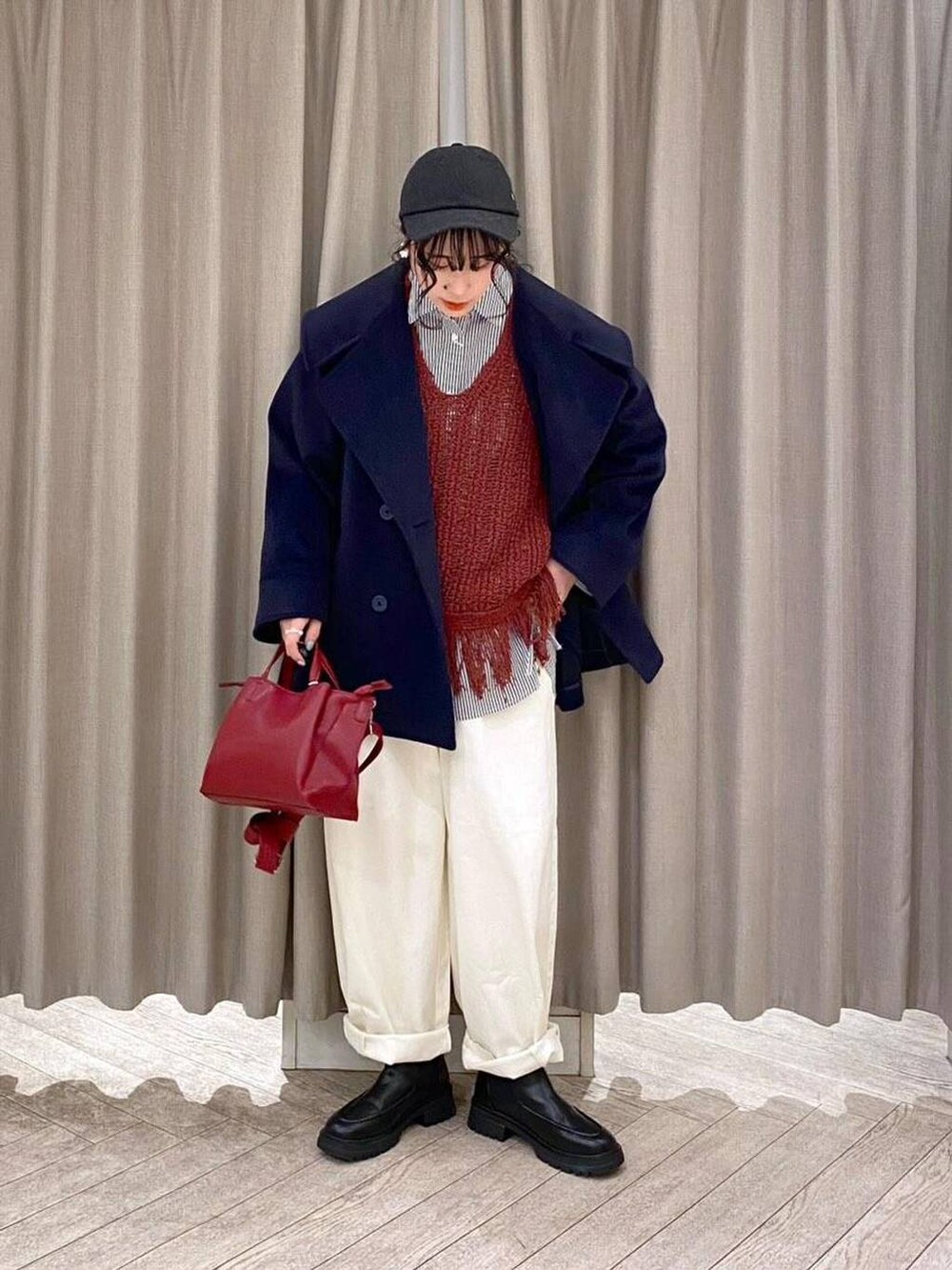 ホワイト系のその他パンツ、ブラウン系のベスト、ブラック系のブーツを着用したレディースの冬コーディネートの7枚目の写真