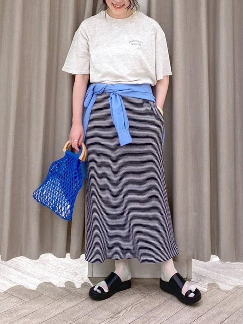 ブラック系のサンダル、ブルー系のハンドバッグ、ブルー系のシャツ/ブラウスを着用したレディースの夏コーディネートの7枚目の写真