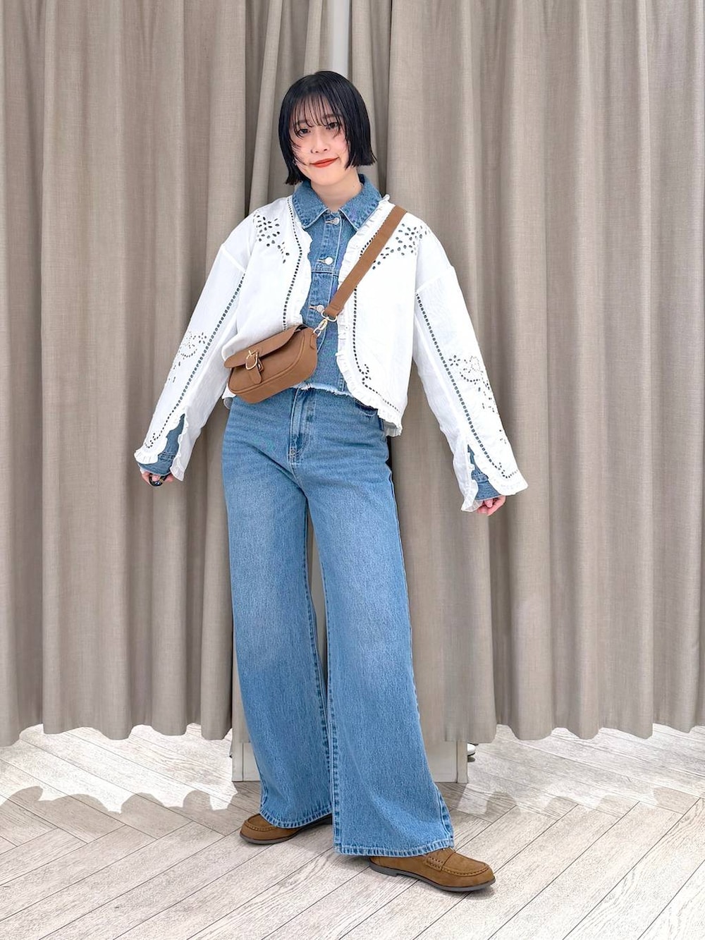 イエロー系のショルダーバッグ、イエロー系のローファー、ブルー系のデニムパンツを着用したレディースの春コーディネートの3枚目の写真