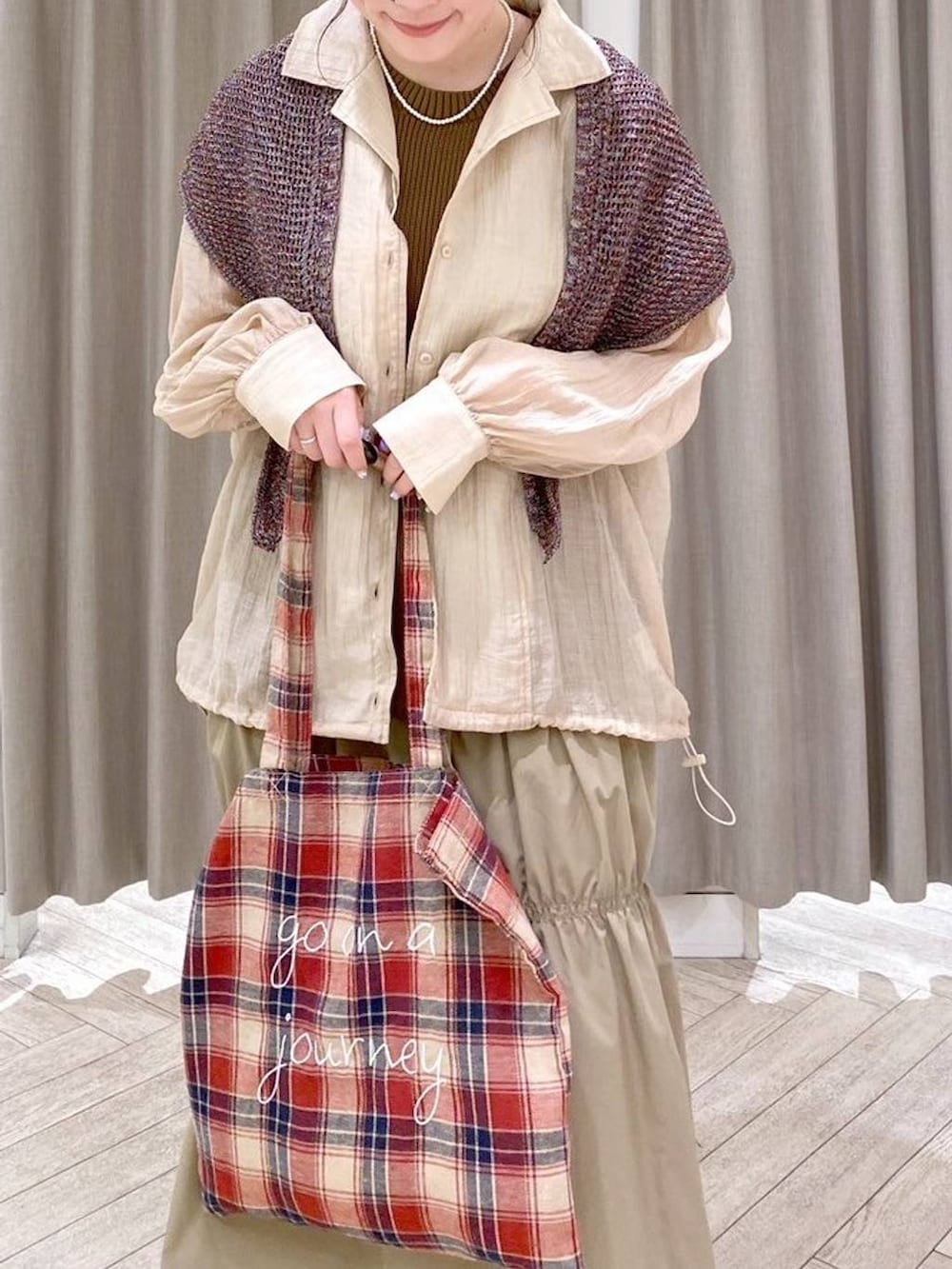 レッド系のパンプス、ベージュ系のナイロンジャケット、ベージュ系のワンピースを着用したレディースの秋コーディネートの5枚目の写真