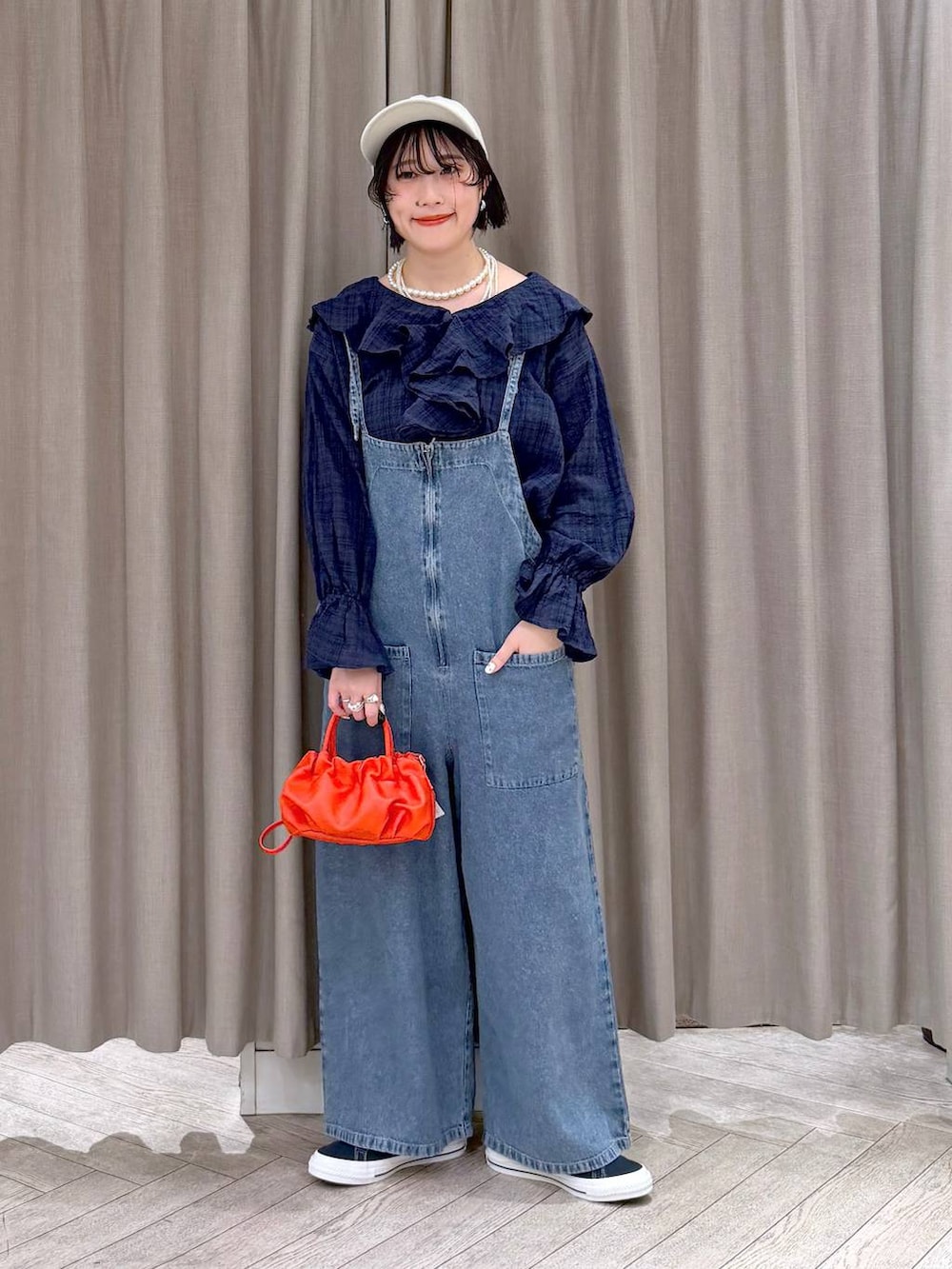 ブルー系のスニーカー、ブルー系のサロペット/オーバーオール、オレンジ系のショルダーバッグを着用したレディースの冬コーディネートの8枚目の写真