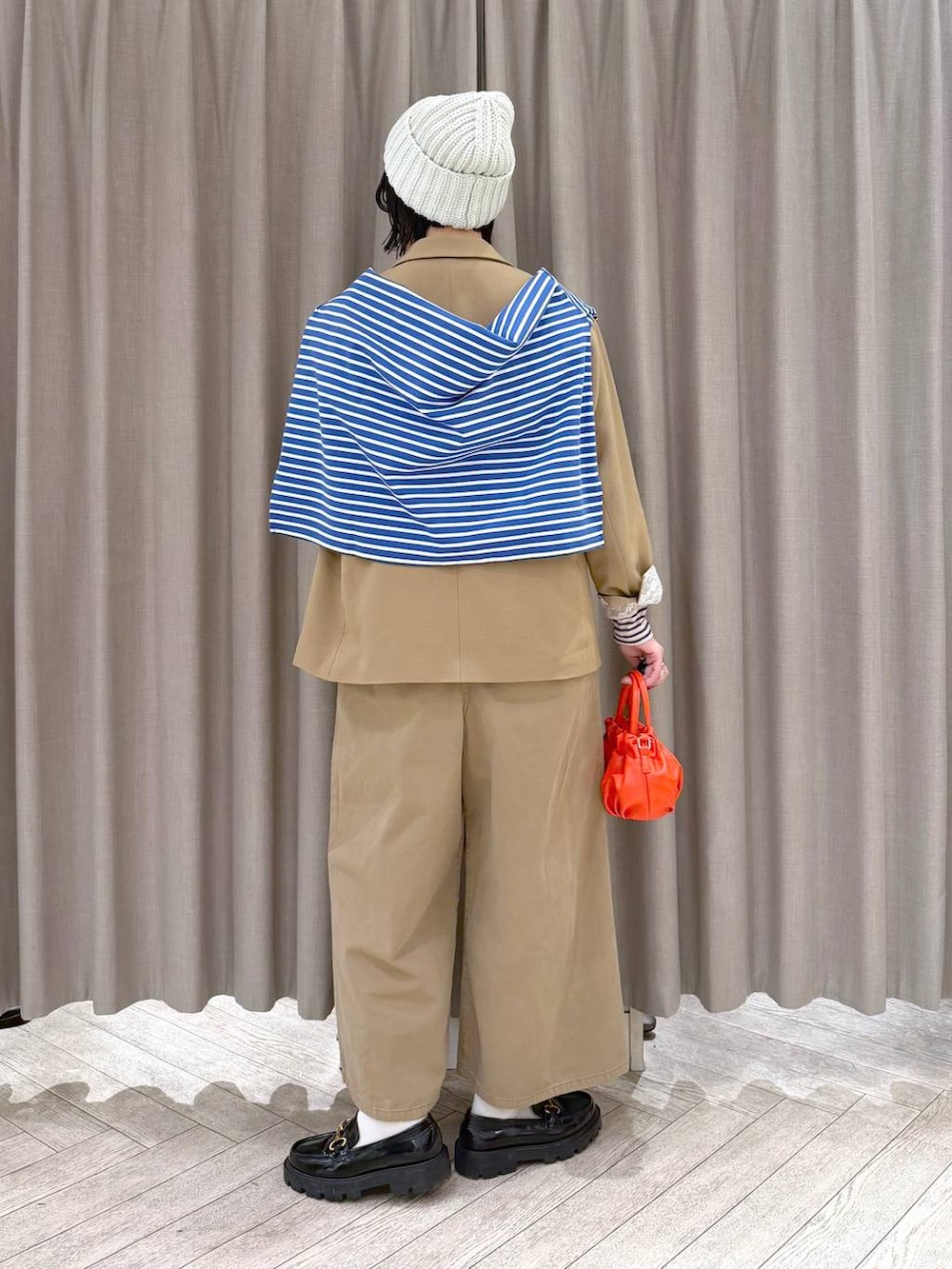 ブラック系のローファー、ベージュ系のサロペット/オーバーオール、オレンジ系のショルダーバッグを着用したレディースの冬コーディネートの4枚目の写真