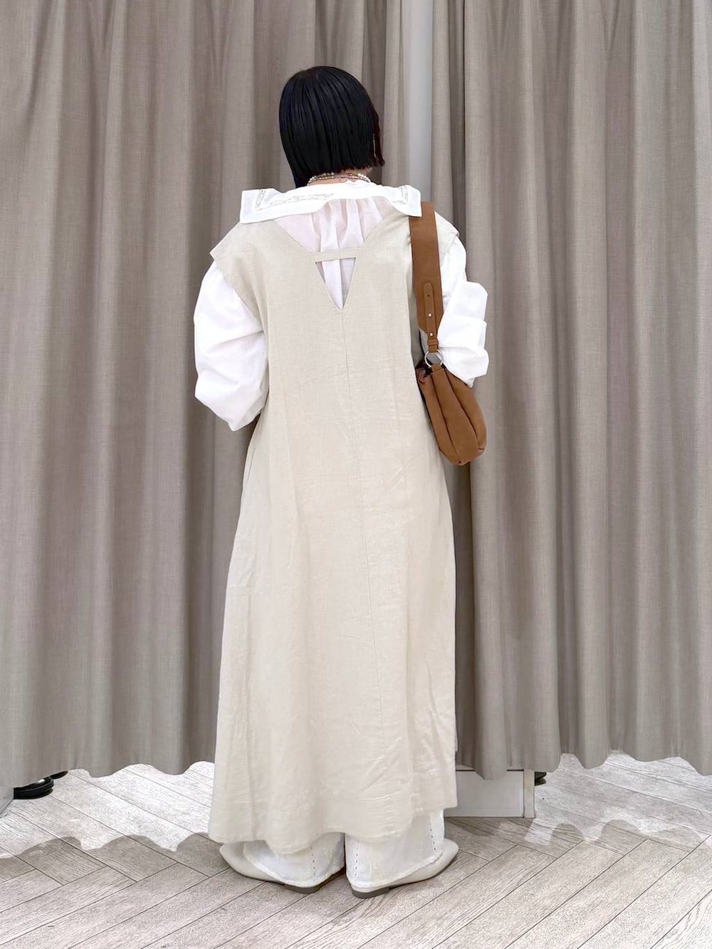 ベージュ系のジャンパースカート、ベージュ系のパンプス、ベージュ系のトートバッグを着用したレディースの冬コーディネートの5枚目の写真