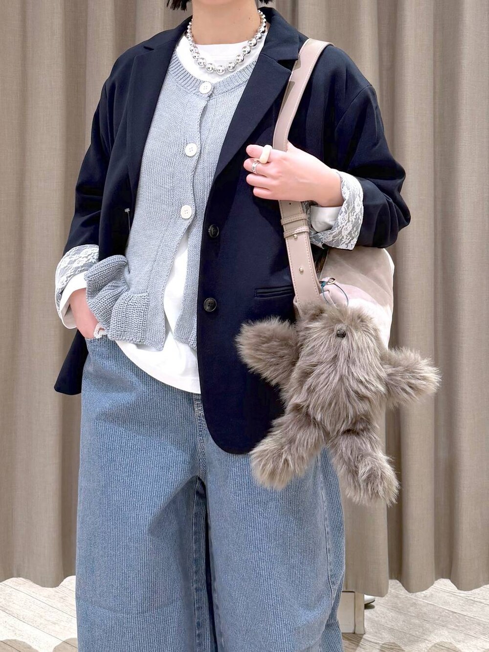 ブルー系のデニムパンツ、ブルー系のテーラードジャケット、グレー系のショルダーバッグを着用したレディースの春コーディネートの6枚目の写真