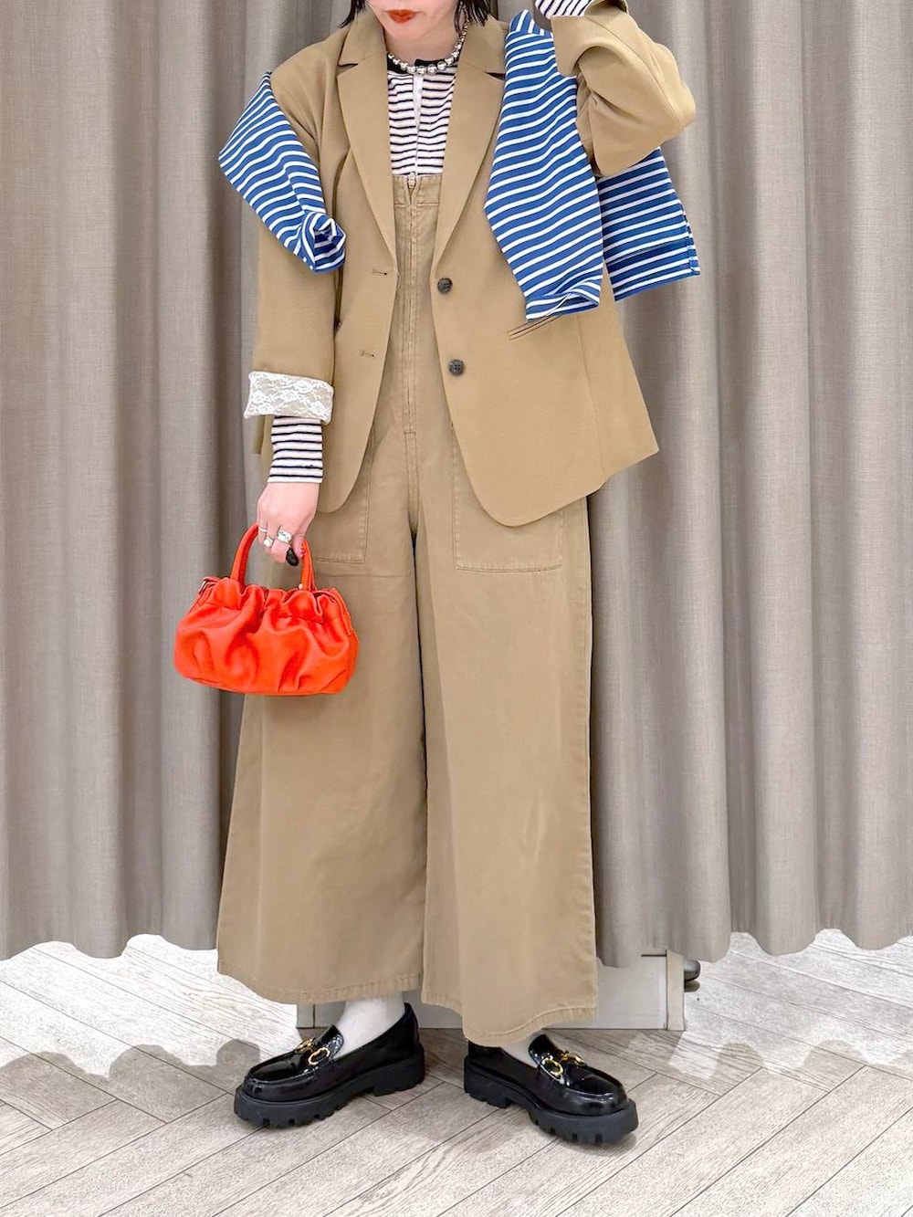 ブラック系のローファー、ベージュ系のサロペット/オーバーオール、オレンジ系のショルダーバッグを着用したレディースの冬コーディネートの8枚目の写真