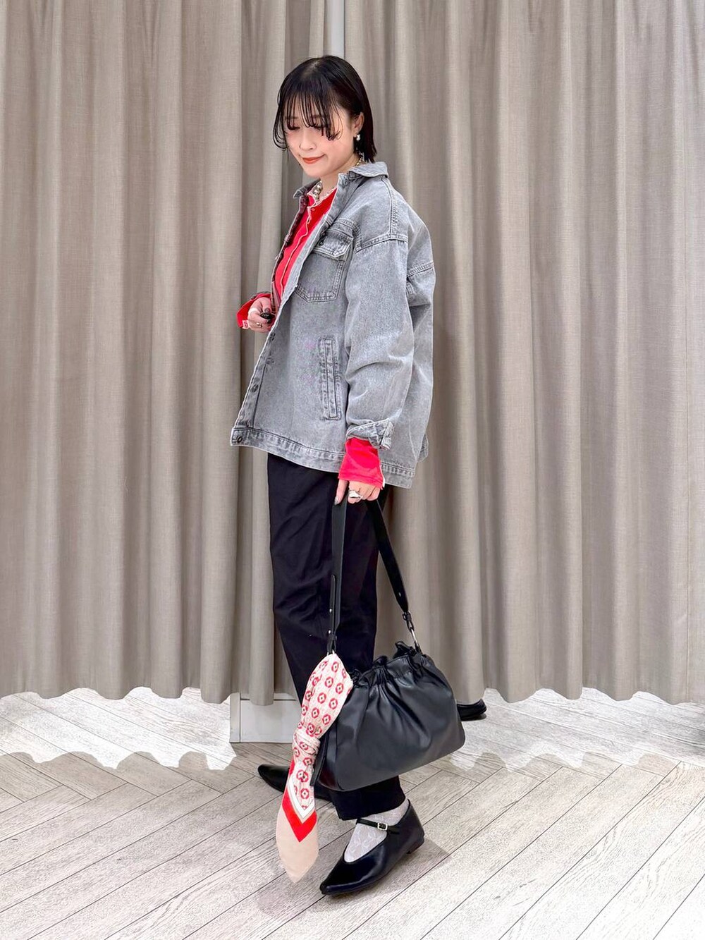 グレー系のデニムジャケット、ブラック系のトートバッグ、ブラック系のその他パンツを着用したレディースの春コーディネートの3枚目の写真