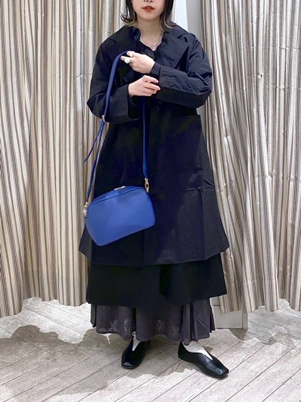 ブラック系のシャツ/ブラウス、ブラック系のジャンパースカート、ブラック系のスカートを着用したレディースの春コーディネートの6枚目の写真