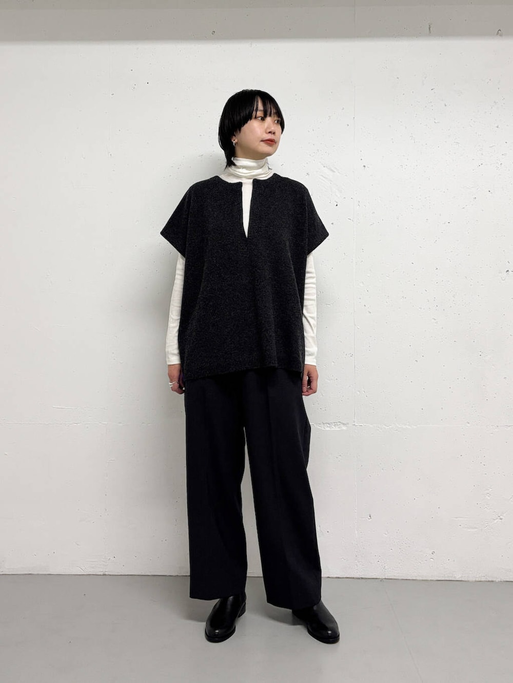 グレー系のその他パンツ、グレー系のニット/セーター、ホワイト系のTシャツ/カットソーを着用したレディースの冬コーディネートの2枚目の写真