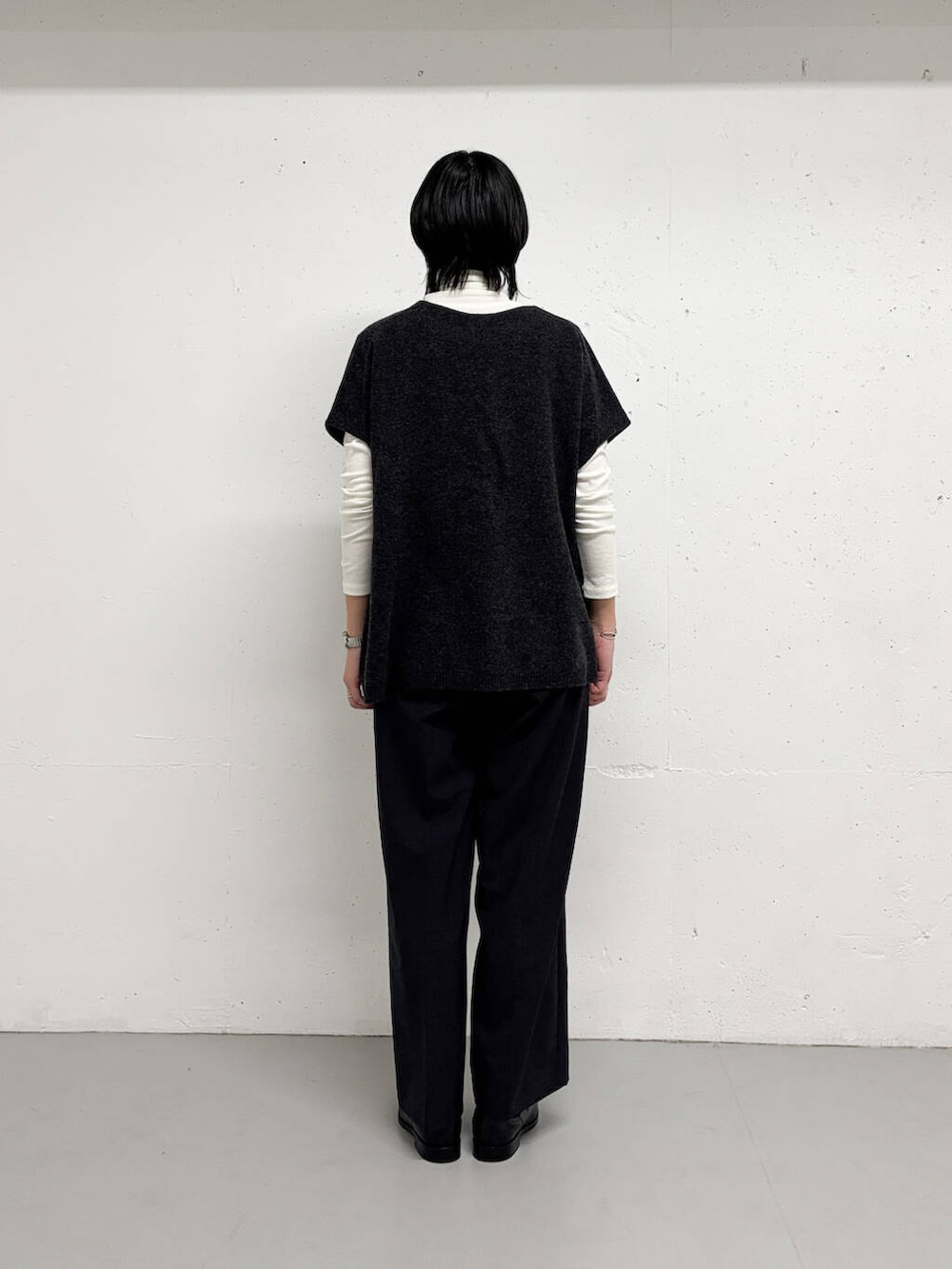 グレー系のその他パンツ、グレー系のニット/セーター、ホワイト系のTシャツ/カットソーを着用したレディースの冬コーディネートの3枚目の写真